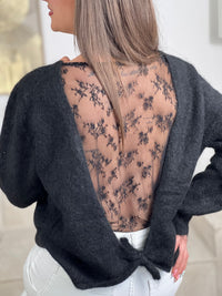 Découvrez le charme intemporel du pull Hélène, un tricot en laine noir qui allie élégance et féminité. Avec ses manches longues et son col rond classique, ce pull offre confort et chaleur au quotidien. Le détail signature ? Un dos nu orné de dentelle transparente à nouer, créant une silhouette sophistiquée et moderne.