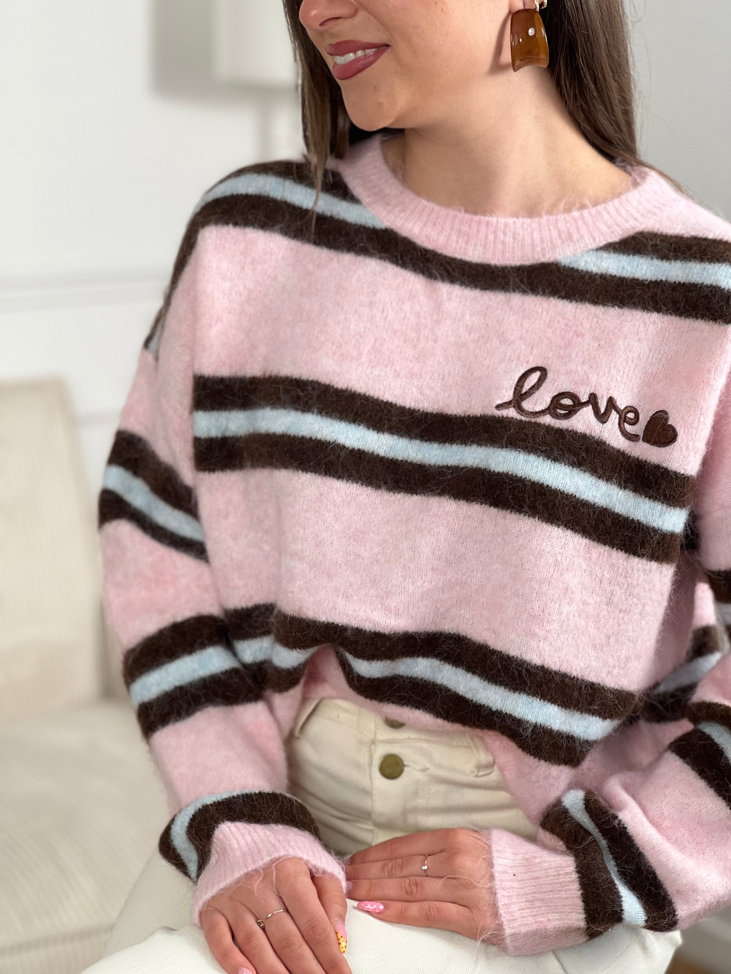 Un incontournable de votre garde-robe automne-hiver. Ce pull femme en laine allie confort et style avec ses manches longues et son col rond épuré. Les rayures horizontales marron et bleues créent une harmonie visuelle intemporelle, tandis que l'inscription "Love" ornée d'un cœur marron ajoute une touche de tendresse au devant.