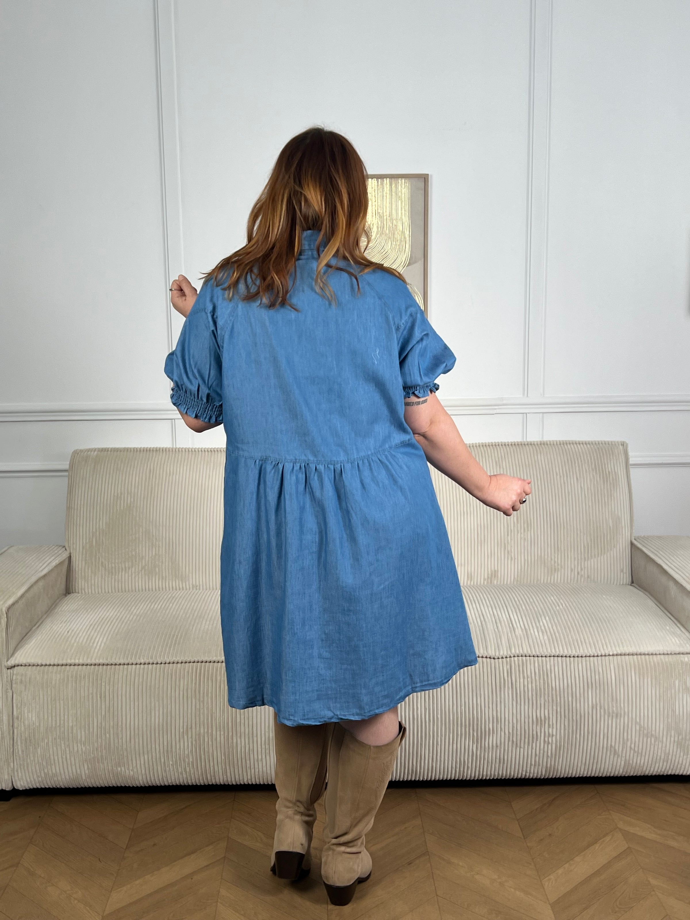 Robe bleue incontournable en pur coton, conçue pour les femmes du 34 au 50. Dotée d'un col chemise élégant et de manches courtes élastiques, elle offre confort et liberté de mouvement. Les boutons à pression sur toute la longueur permettent un ajustement facile, tandis que les trois poches pratiques (une à la poitrine, deux latérales) ajoutent fonctionnalité au style.