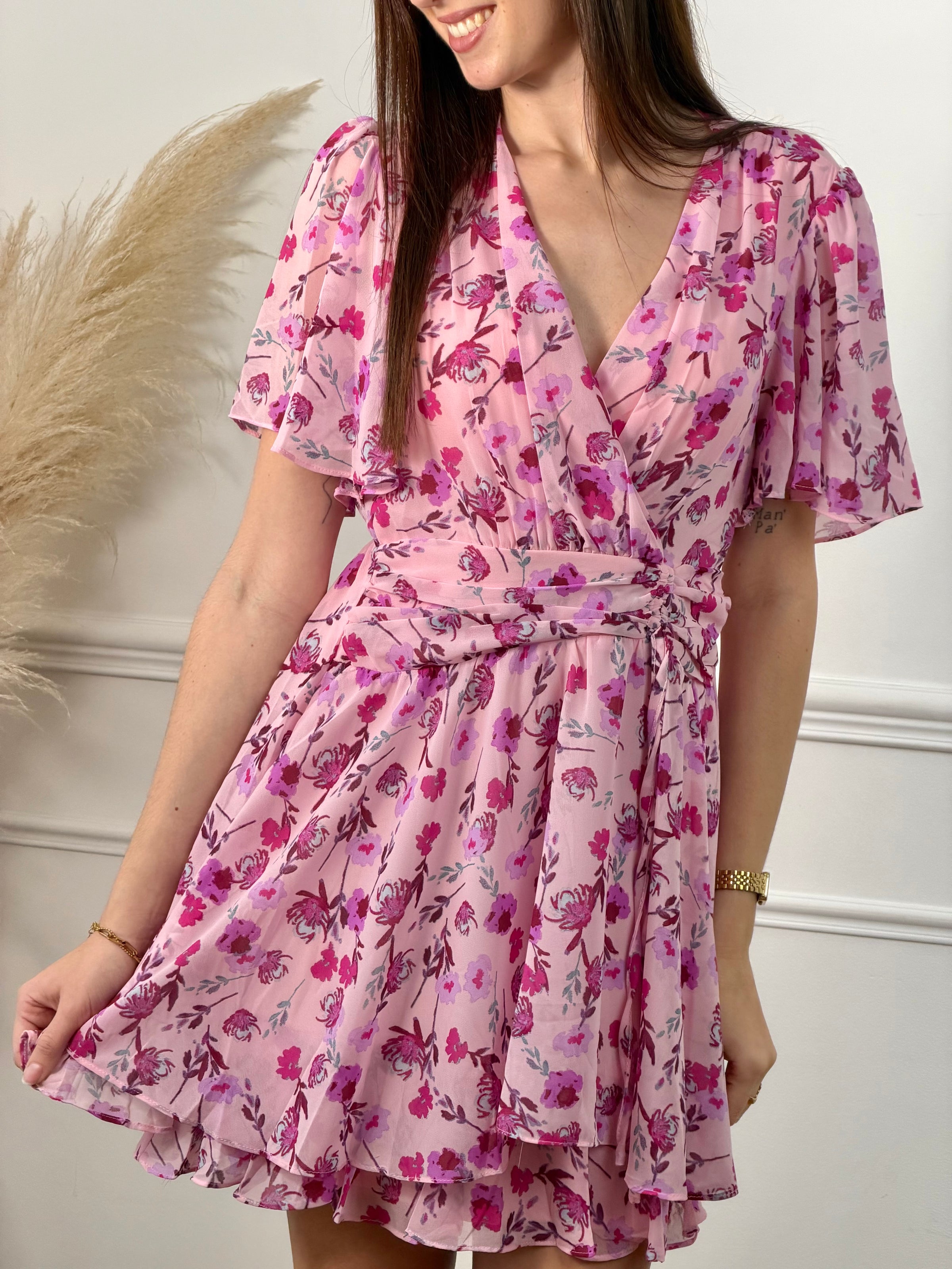 La robe Alma allie élégance et confort. Son col cache-cœur avec clip et ses manches courtes mettent en valeur votre silhouette, tandis que l'élastique au dos garantit un ajustement sur mesure. Les motifs fleuris et le lien factice à nouer à l'avant créent une allure féminine et dynamique.