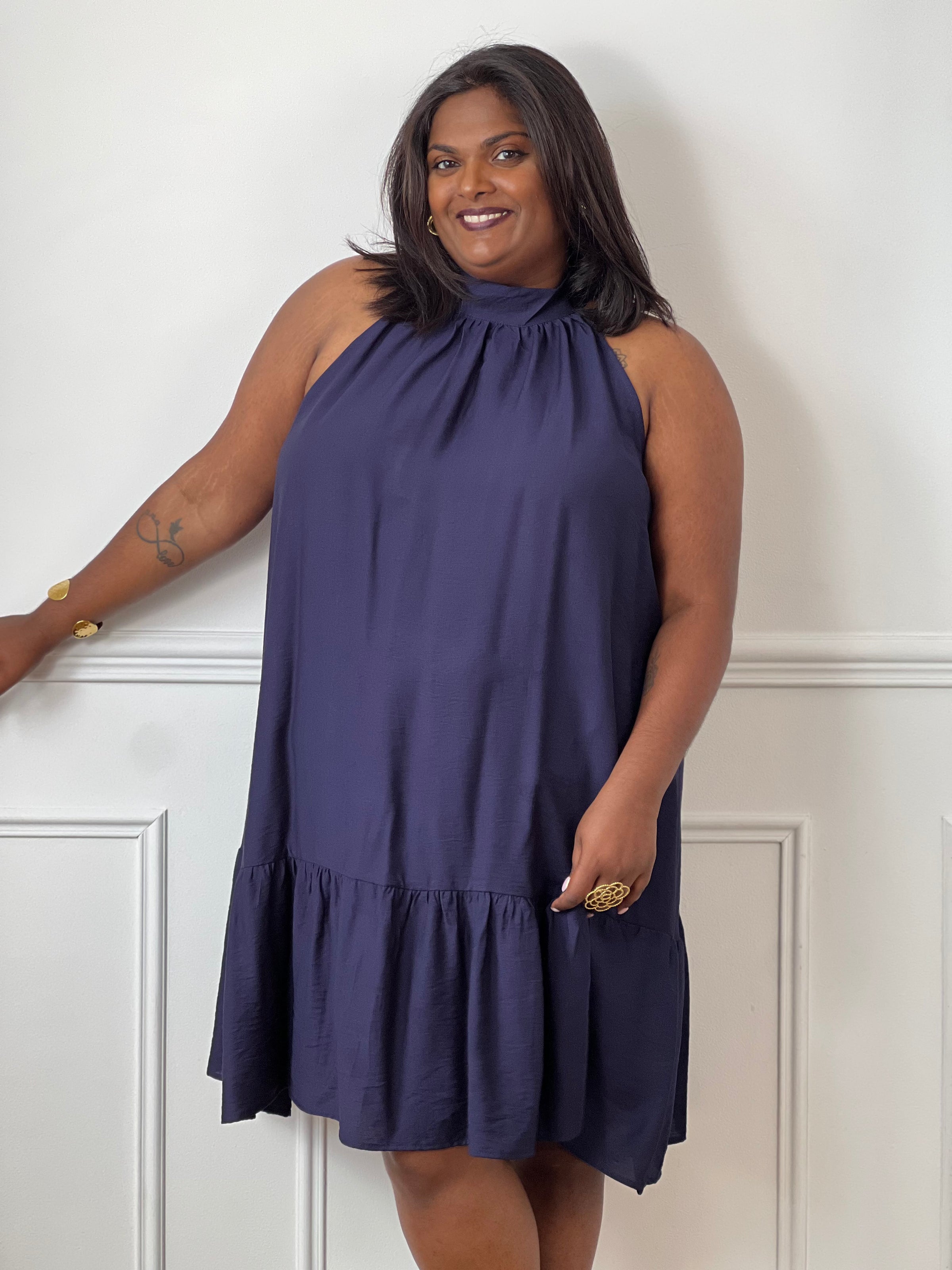 Élégante et aérienne, cette robe bleu marine grande taille est parfaite pour créer un look féminin et raffiné. Son col montant à nouer, son dos nu et sa coupe évasée lui confèrent une allure chic tout en restant agréable à porter. Sa matière légèrement transparente apporte une touche de légèreté idéale pour la belle saison.