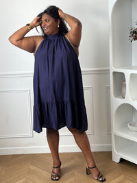 Élégante et aérienne, cette robe bleu marine grande taille est parfaite pour créer un look féminin et raffiné. Son col montant à nouer, son dos nu et sa coupe évasée lui confèrent une allure chic tout en restant agréable à porter. Sa matière légèrement transparente apporte une touche de légèreté idéale pour la belle saison.