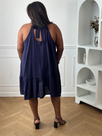 Élégante et aérienne, cette robe bleu marine grande taille est parfaite pour créer un look féminin et raffiné. Son col montant à nouer, son dos nu et sa coupe évasée lui confèrent une allure chic tout en restant agréable à porter. Sa matière légèrement transparente apporte une touche de légèreté idéale pour la belle saison.