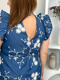 Craquez pour cette robe en coton grande taille, ornée de délicates fleurs brodées bleu marine et écru. Son col cache-cœur devant et dos, ses volants aux épaules, sa taille élastiquée et son lien à nouer dans le dos offrent une coupe féminine et confortable. Doublée, elle est parfaite pour la belle saison.