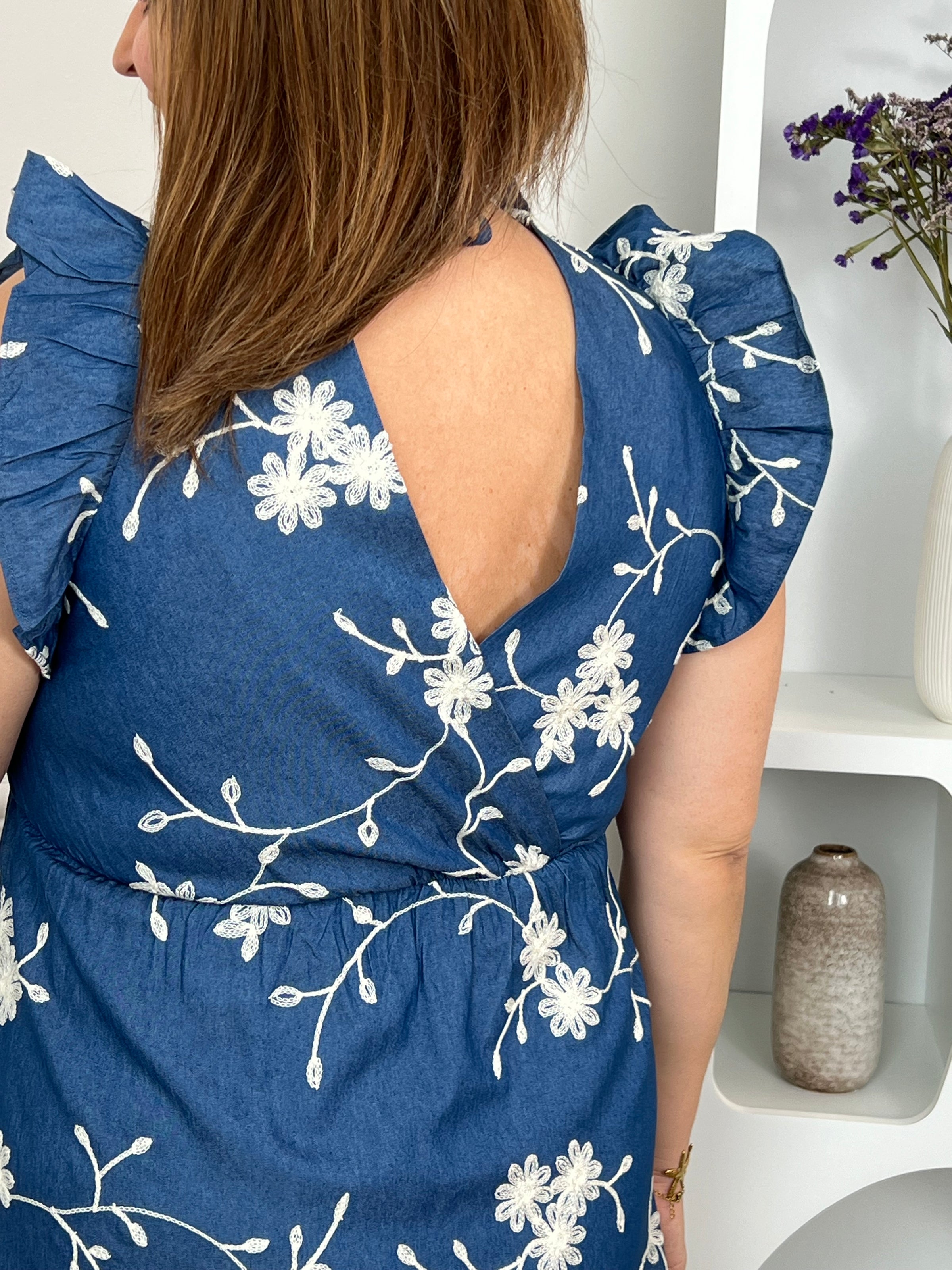 Craquez pour cette robe en coton grande taille, ornée de délicates fleurs brodées bleu marine et écru. Son col cache-cœur devant et dos, ses volants aux épaules, sa taille élastiquée et son lien à nouer dans le dos offrent une coupe féminine et confortable. Doublée, elle est parfaite pour la belle saison.