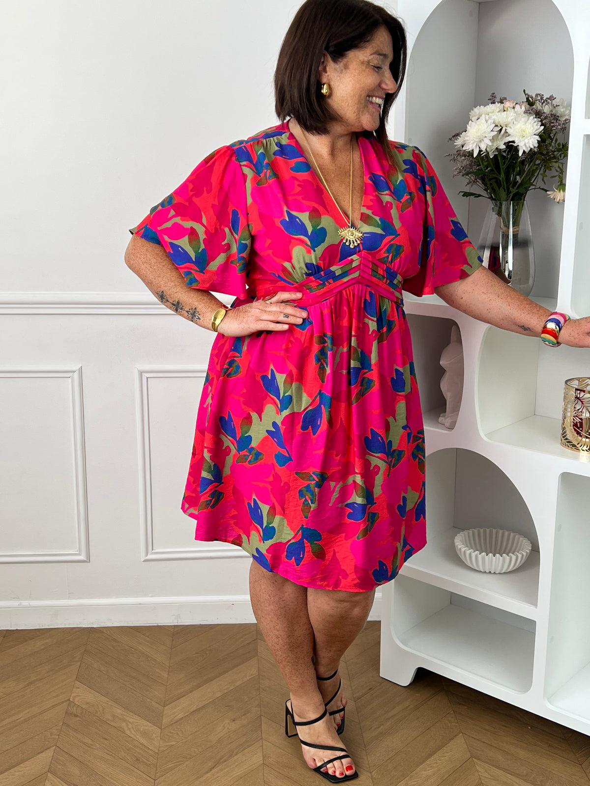 Cette robe courte fuchsia aux motifs corail bleu et vert allie confort et élégance grâce à sa coupe fluide qui sublime la silhouette. Son col en V et ses manches courtes apportent une touche de fraîcheur et de féminité.