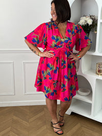Cette robe courte fuchsia aux motifs corail bleu et vert allie confort et élégance grâce à sa coupe fluide qui sublime la silhouette. Son col en V et ses manches courtes apportent une touche de fraîcheur et de féminité.