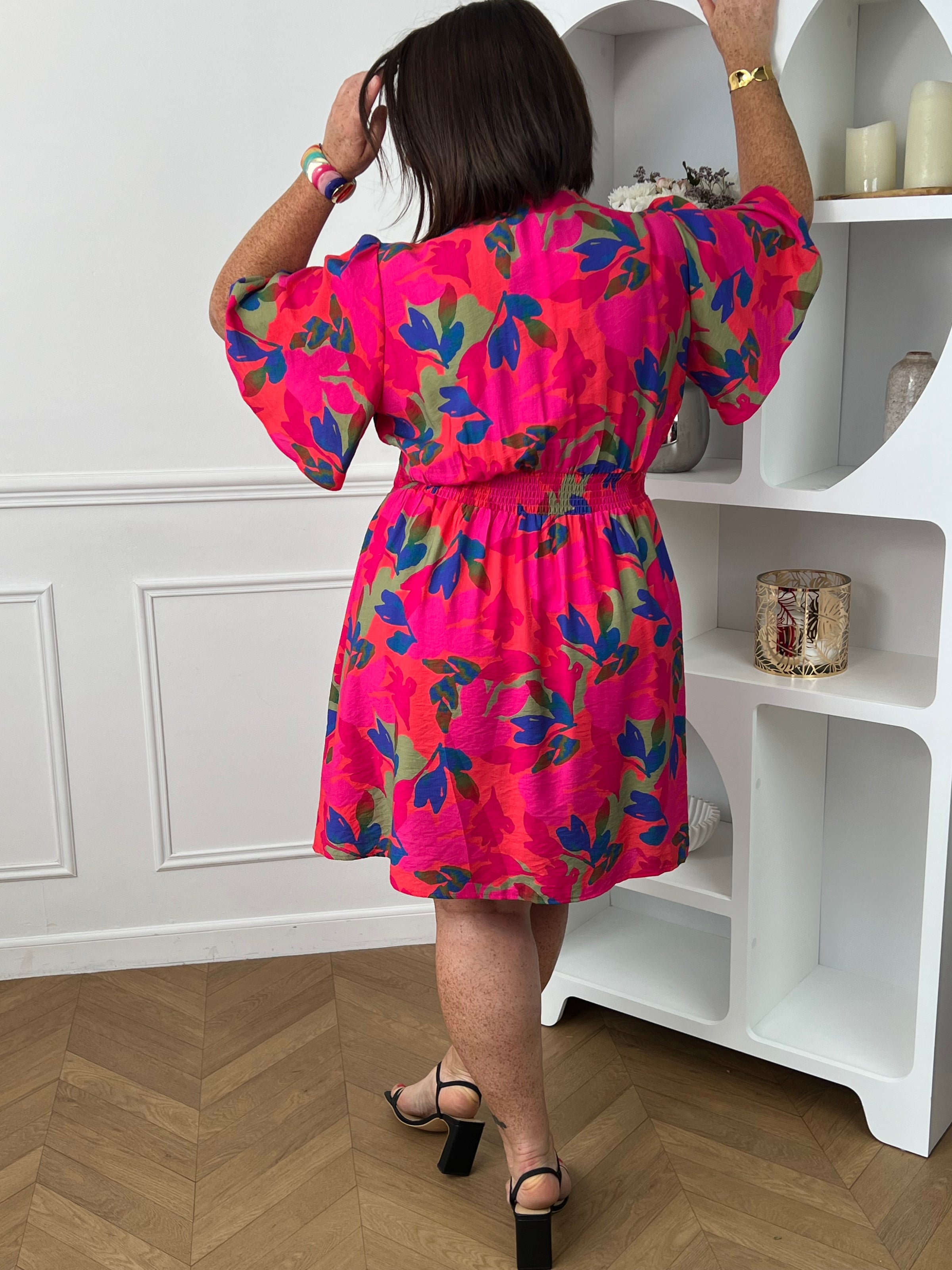 Cette robe courte fuchsia aux motifs corail bleu et vert allie confort et élégance grâce à sa coupe fluide qui sublime la silhouette. Son col en V et ses manches courtes apportent une touche de fraîcheur et de féminité.