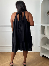 Sublimez votre silhouette avec cette robe noire grande taille au style élégant et féminin. Sa coupe évasée apporte fluidité et confort, tandis que son col montant avec lien à nouer ajoute une touche raffinée. Sans manches et dotée d’un dos nu séduisant, elle est idéale pour les journées ensoleillées comme pour les occasions spéciales. Légèrement transparente, cette robe noire allie légèreté et sophistication pour un look résolument chic.