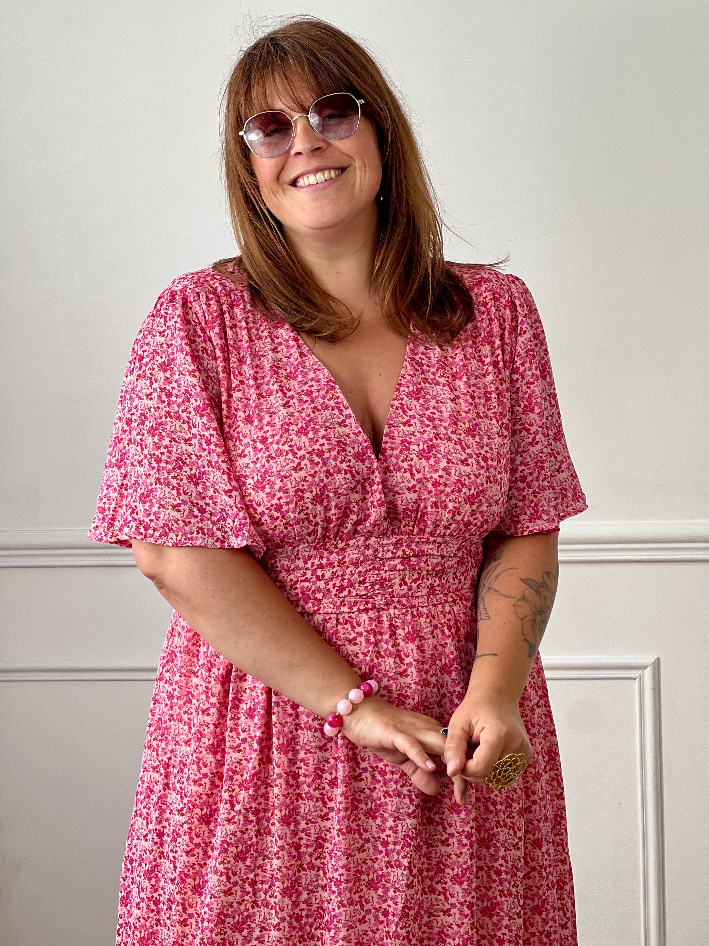 Apportez une touche de couleur et de féminité à votre dressing avec cette robe longue grande taille à motifs fleuris. Son col V et ses manches courtes lui confèrent une allure élégante et légère, tandis que sa taille élastiquée au dos assure un confort optimal et une silhouette harmonieuse. Doublée sur le corps pour plus d’aisance, elle reste légèrement transparente au niveau des manches pour un effet aérien.