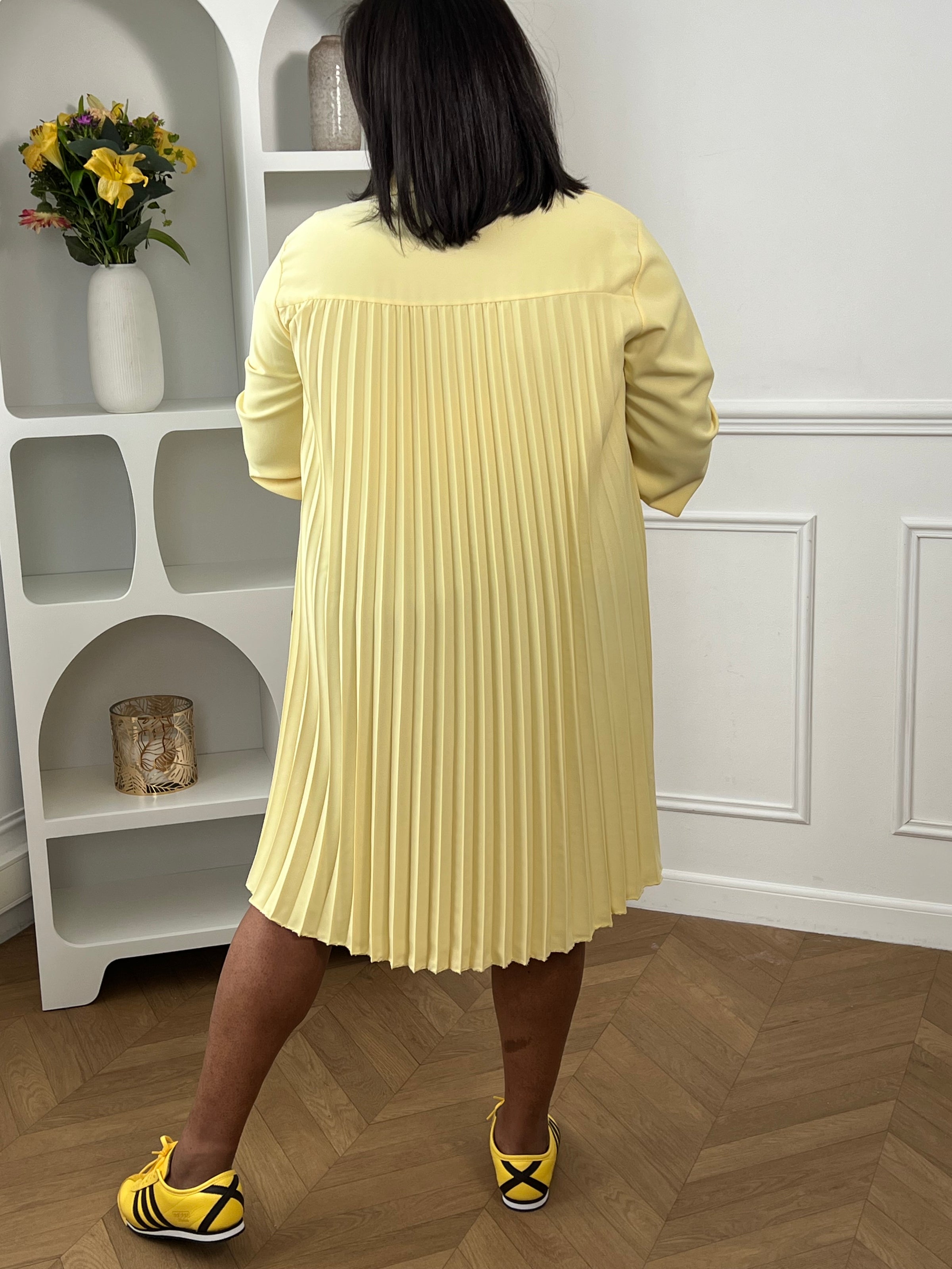La texture plissée ajoute une touche de mouvement et de style, tandis que la couleur jaune apporte une note classique. Cette pièce est idéale pour des occasions décontractées ou plus habillées, permettant aux femmes de grande taille de rayonner avec confiance dans une robe chic et flatteuse.