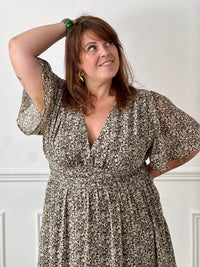 Apportez une touche de couleur et de féminité à votre dressing avec cette robe longue grande taille à motifs fleuris. Son col V et ses manches courtes lui confèrent une allure élégante et légère, tandis que sa taille élastiquée au dos assure un confort optimal et une silhouette harmonieuse. Doublée sur le corps pour plus d’aisance, elle reste légèrement transparente au niveau des manches pour un effet aérien. Ses motifs floraux aux nuances de marron, vert, jaune et rose en font une pièce idéale pour la sais