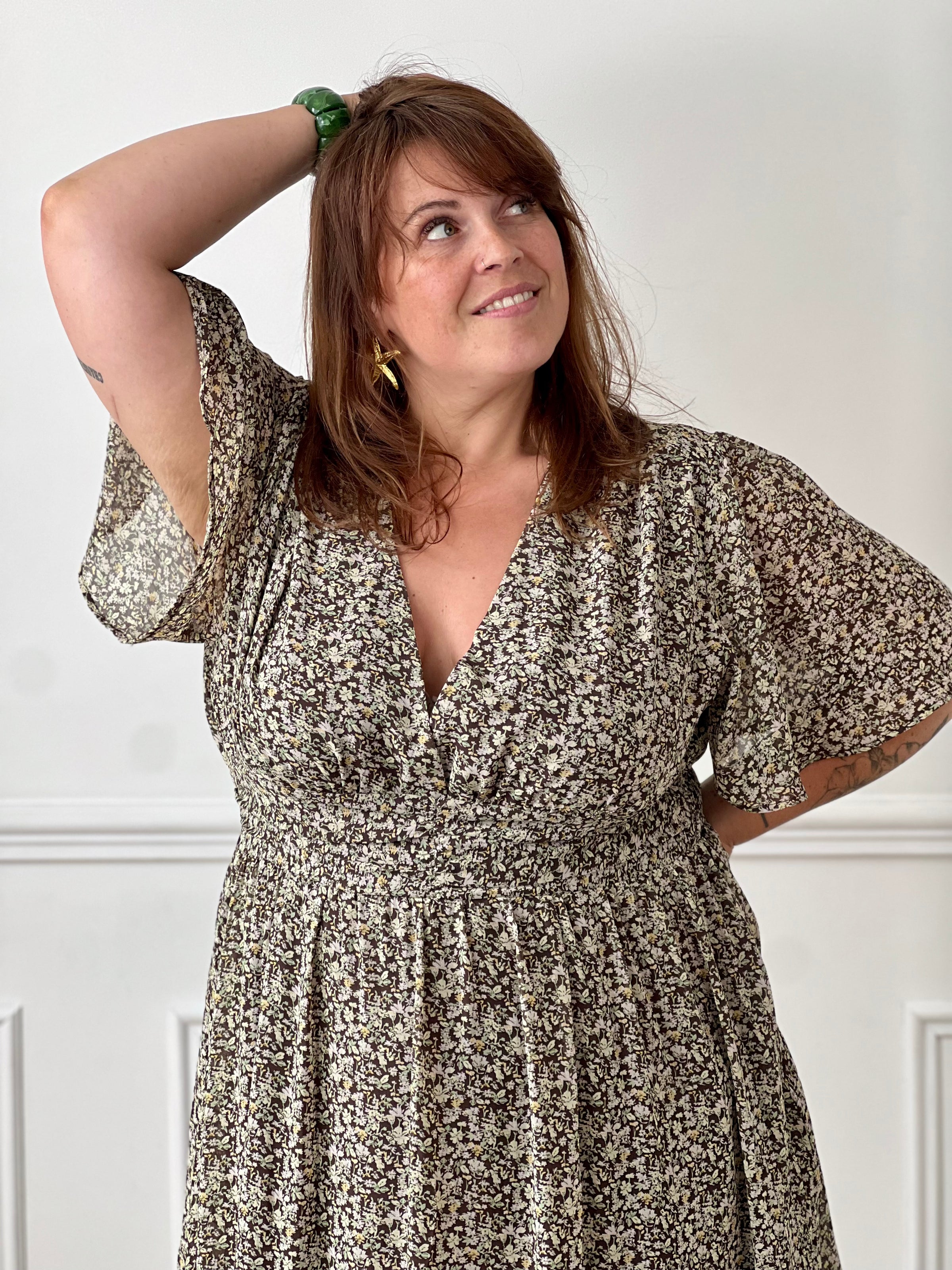 Apportez une touche de couleur et de féminité à votre dressing avec cette robe longue grande taille à motifs fleuris. Son col V et ses manches courtes lui confèrent une allure élégante et légère, tandis que sa taille élastiquée au dos assure un confort optimal et une silhouette harmonieuse. Doublée sur le corps pour plus d’aisance, elle reste légèrement transparente au niveau des manches pour un effet aérien. Ses motifs floraux aux nuances de marron, vert, jaune et rose en font une pièce idéale pour la sais