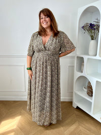 Apportez une touche de couleur et de féminité à votre dressing avec cette robe longue grande taille à motifs fleuris. Son col V et ses manches courtes lui confèrent une allure élégante et légère, tandis que sa taille élastiquée au dos assure un confort optimal et une silhouette harmonieuse. Doublée sur le corps pour plus d’aisance, elle reste légèrement transparente au niveau des manches pour un effet aérien. Ses motifs floraux aux nuances de marron, vert, jaune et rose en font une pièce idéale pour la sais