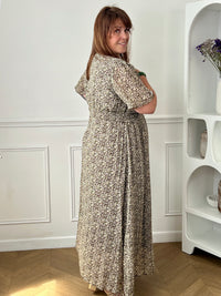 Apportez une touche de couleur et de féminité à votre dressing avec cette robe longue grande taille à motifs fleuris. Son col V et ses manches courtes lui confèrent une allure élégante et légère, tandis que sa taille élastiquée au dos assure un confort optimal et une silhouette harmonieuse. Doublée sur le corps pour plus d’aisance, elle reste légèrement transparente au niveau des manches pour un effet aérien. Ses motifs floraux aux nuances de marron, vert, jaune et rose en font une pièce idéale pour la sais