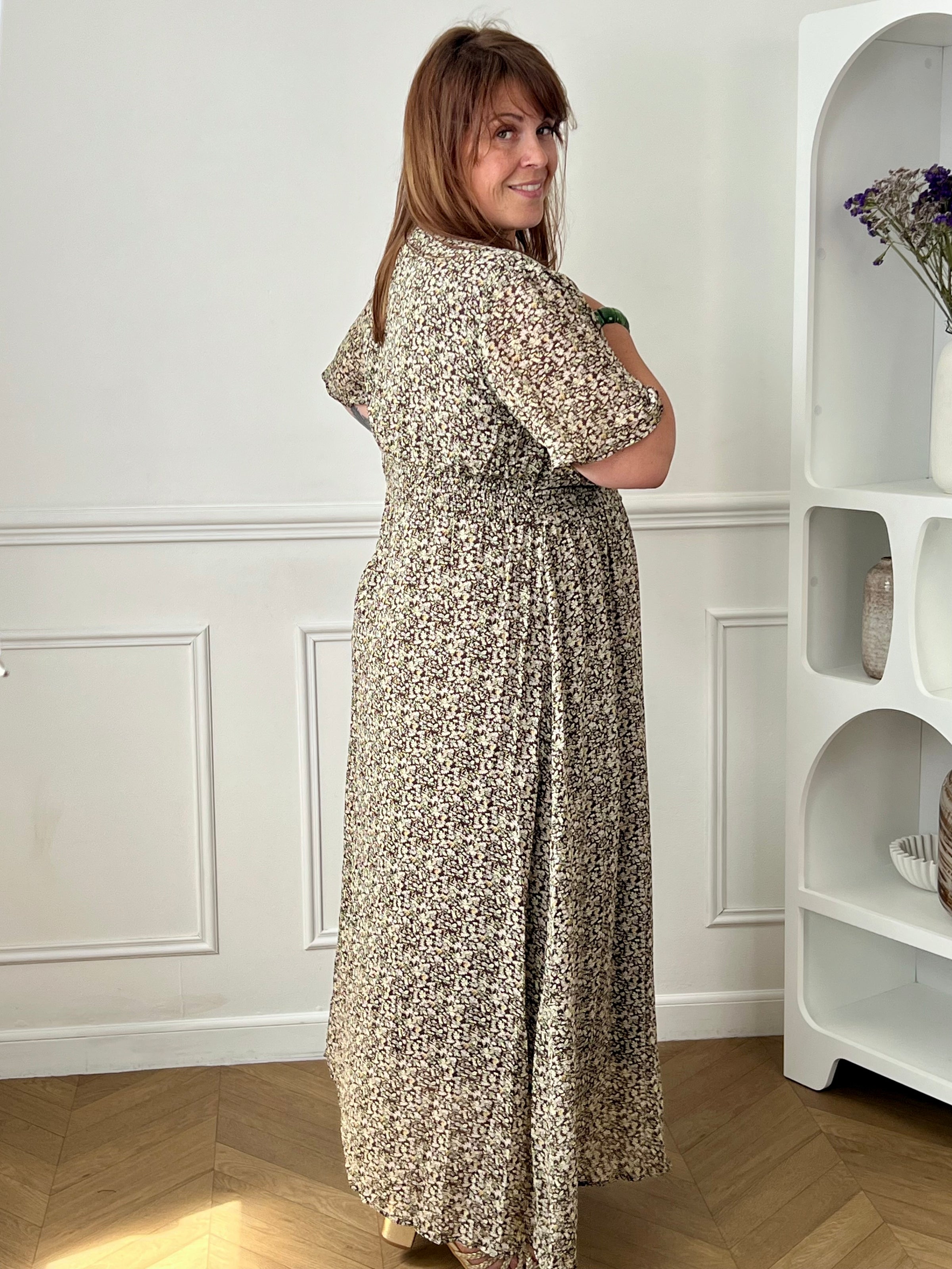 Apportez une touche de couleur et de féminité à votre dressing avec cette robe longue grande taille à motifs fleuris. Son col V et ses manches courtes lui confèrent une allure élégante et légère, tandis que sa taille élastiquée au dos assure un confort optimal et une silhouette harmonieuse. Doublée sur le corps pour plus d’aisance, elle reste légèrement transparente au niveau des manches pour un effet aérien. Ses motifs floraux aux nuances de marron, vert, jaune et rose en font une pièce idéale pour la sais
