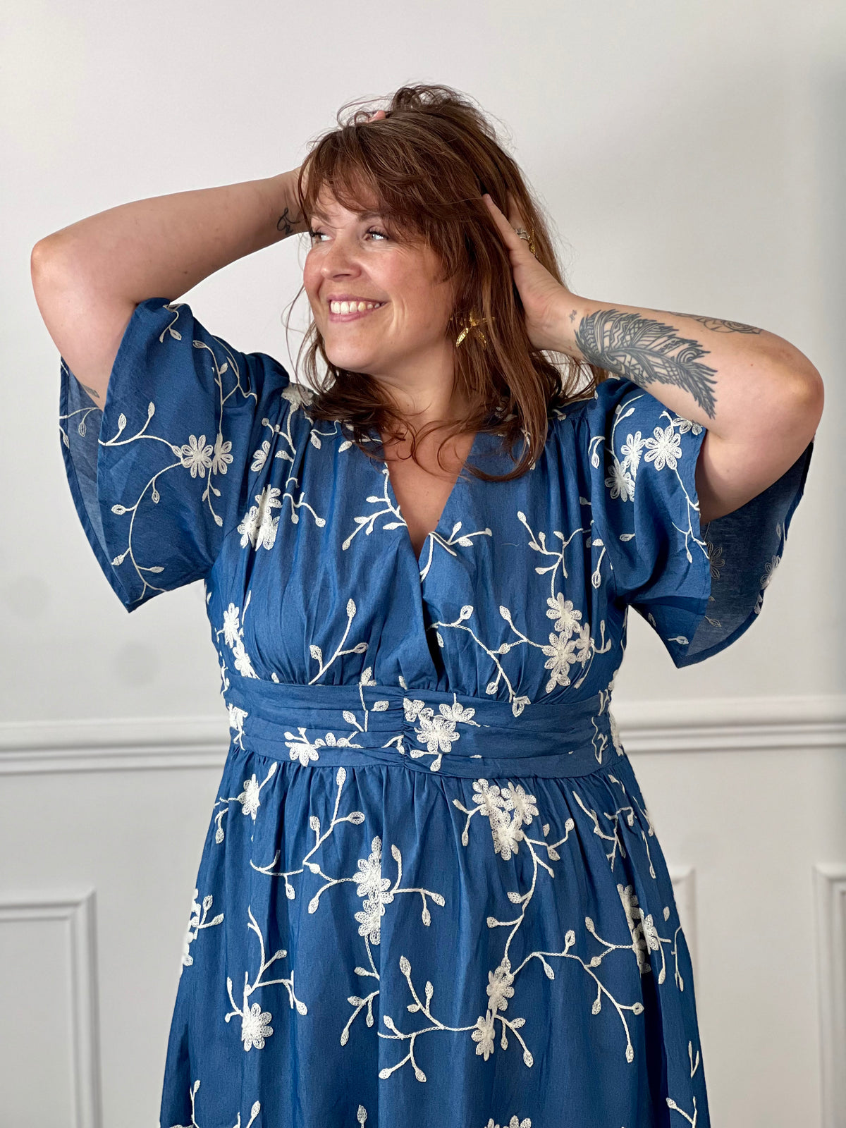 Craquez pour cette robe longue en coton grande taille femme, parfaite pour une allure élégante et confortable. Dotée d'un col V, de manches courtes et d'une taille élastiquée au dos, elle met en valeur la silhouette. Ses délicats motifs fleurs brodés dans des tons bleu marine et écru apportent une touche raffinée, idéale pour la belle saison.