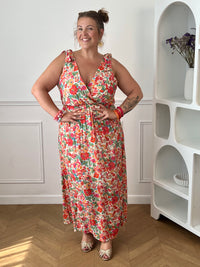 Laissez-vous séduire par cette robe longue à motif floral, idéale pour un look féminin et élégant. Son col cache-cœur à l'avant comme à l'arrière sublime la silhouette, tandis que le lien à nouer à la nuque apporte une touche raffinée. Sans manches et dotée d'une taille élastiquée, elle offre un confort optimal tout au long de la journée.