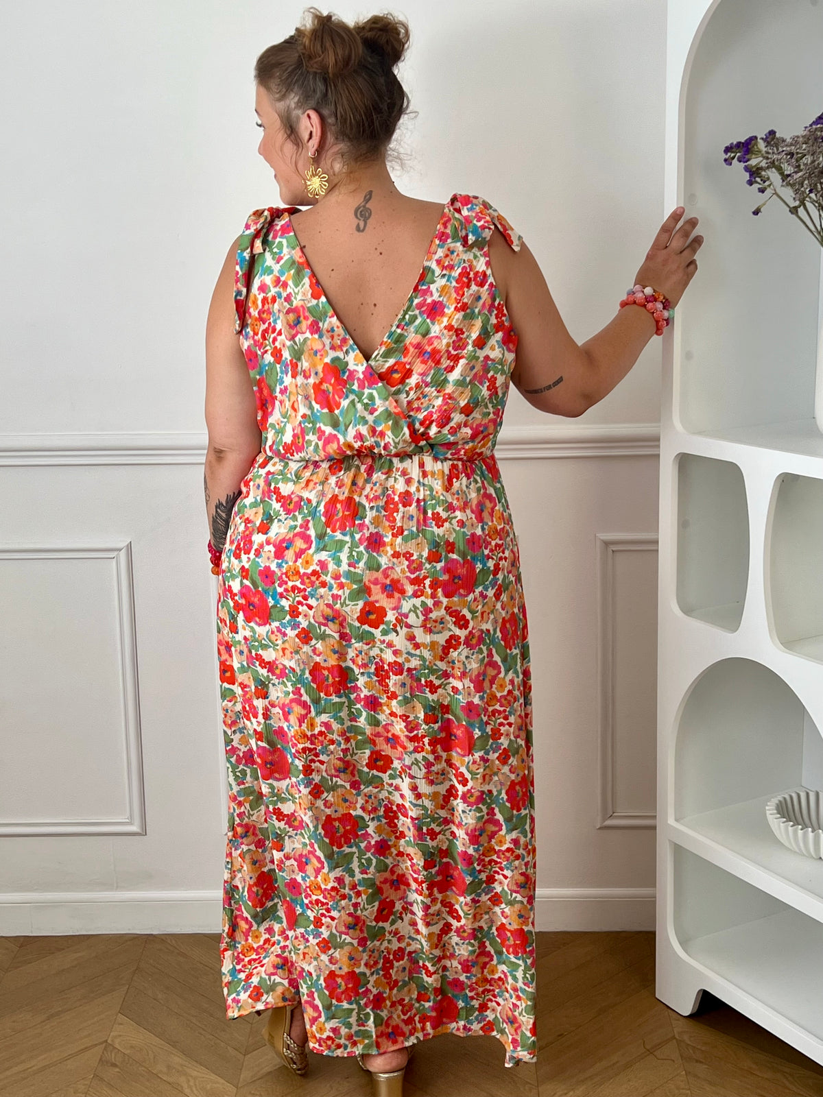 Laissez-vous séduire par cette robe longue à motif floral, idéale pour un look féminin et élégant. Son col cache-cœur à l'avant comme à l'arrière sublime la silhouette, tandis que le lien à nouer à la nuque apporte une touche raffinée. Sans manches et dotée d'une taille élastiquée, elle offre un confort optimal tout au long de la journée.