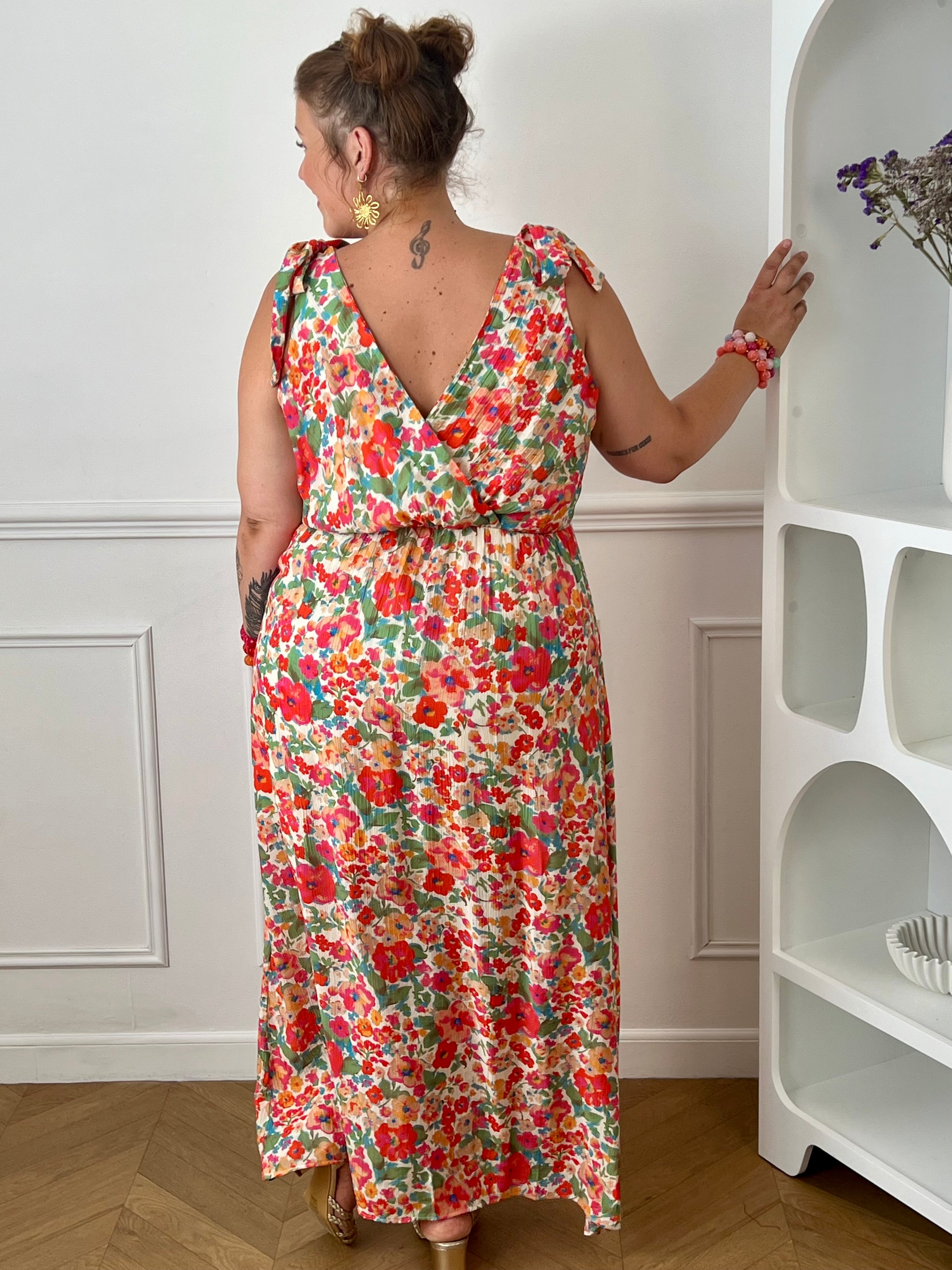 Laissez-vous séduire par cette robe longue à motif floral, idéale pour un look féminin et élégant. Son col cache-cœur à l'avant comme à l'arrière sublime la silhouette, tandis que le lien à nouer à la nuque apporte une touche raffinée. Sans manches et dotée d'une taille élastiquée, elle offre un confort optimal tout au long de la journée.