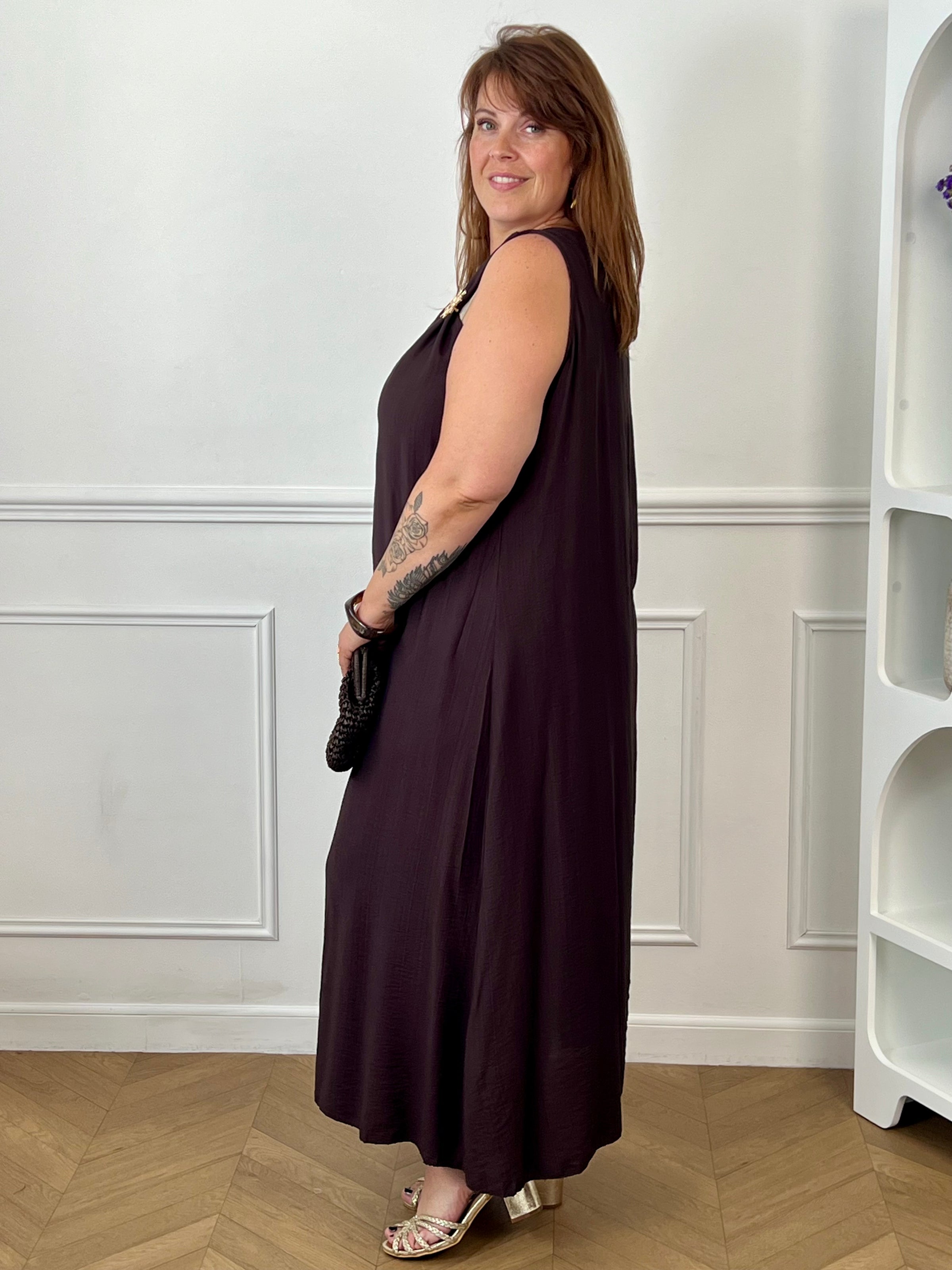 Adoptez cette robe grande taille à bretelles, élégante et facile à porter. Son col rond est sublimé par de jolies broches amovibles en forme de soleils dorés qui apportent une touche originale et raffinée. Sa couleur marron foncé en fait une pièce idéale pour un look chic en toute simplicité.