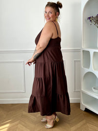 Apportez une touche d'élégance à votre garde-robe avec cette robe longue à bretelles femme. Son col V met délicatement la silhouette en valeur, tandis que les bretelles réglables et l'élastique au dos assurent un ajustement confortable et personnalisé. La broche dorée amovible en forme de soleil apporte une finition raffinée et originale, idéale pour sublimer cette robe marron foncé. Une pièce chic et intemporelle, parfaite pour vos journées d'été comme pour vos occasions spéciales.