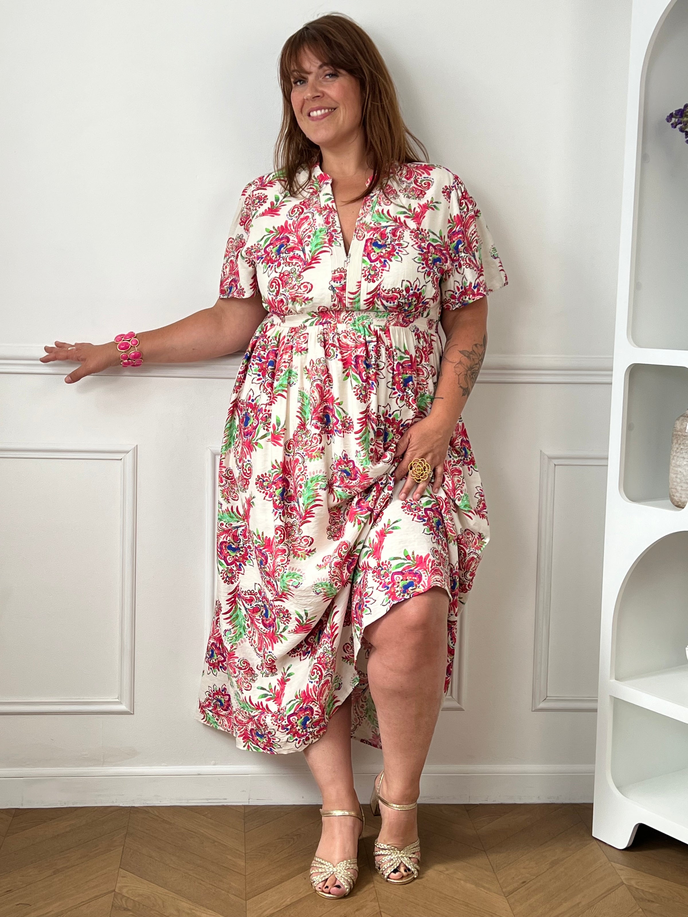 Laissez-vous séduire par cette robe longue écrue grande taille au charme bohème et féminin. Ses motifs colorés aux nuances de rose, vert, bleu et violet apportent une touche de fraîcheur et d’originalité à la silhouette. Dotée de manches courtes et d’un col V élégant, elle offre un confort optimal grâce à sa taille élastiquée au dos. Doublée au niveau de la jupe et sur le devant du haut, cette robe fluide est idéale pour un look à la fois chic, léger et confortable.