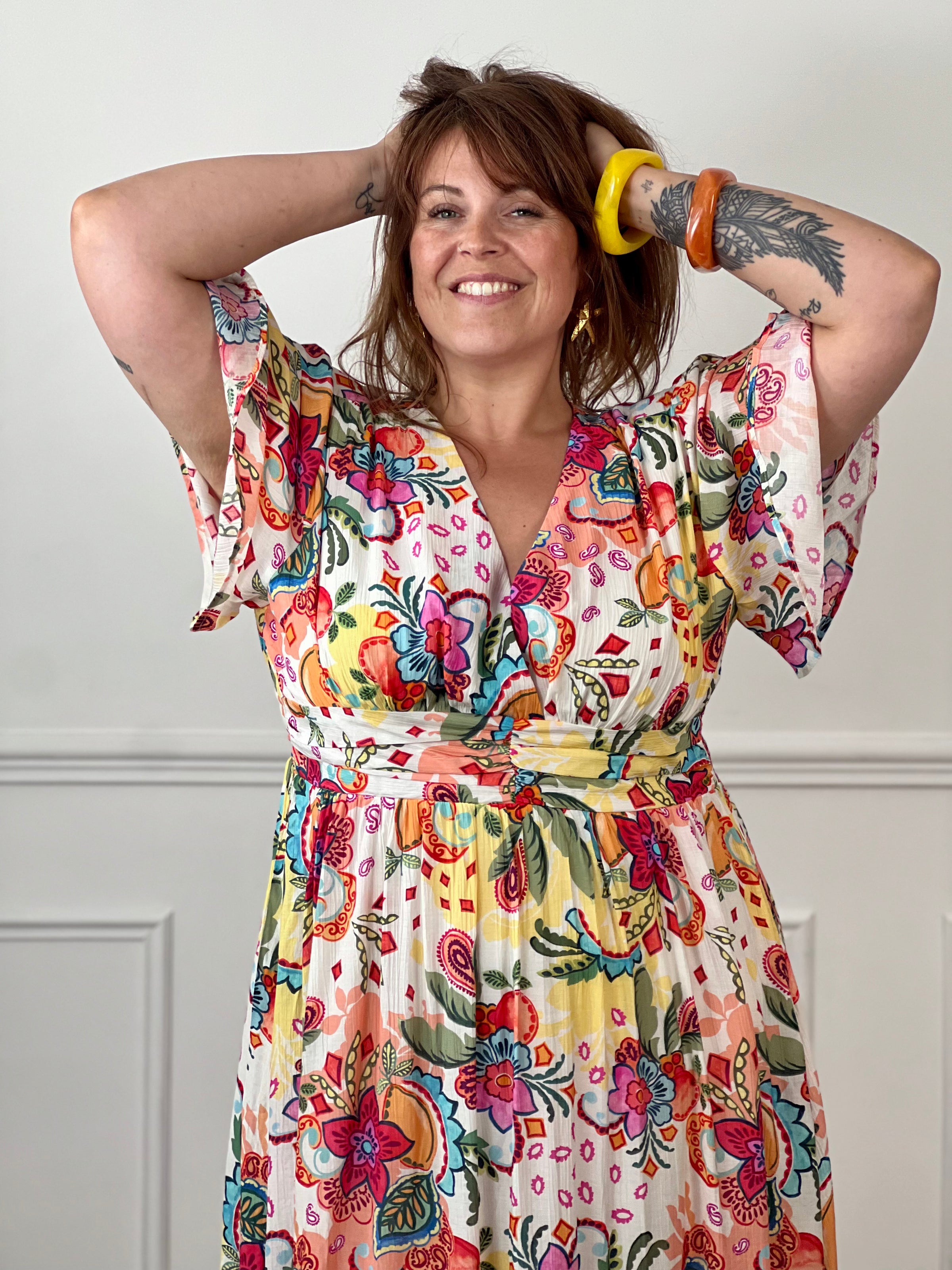 Succombez au charme de cette robe longue à motifs grande taille femme, idéale pour la saison. Son col V, ses manches courtes et sa taille élastiquée au dos offrent une coupe fluide et confortable. Doublée pour plus d'aisance, elle séduit par son imprimé multicolore aux tons écru, rose, bleu, jaune, orange, vert et rouge.