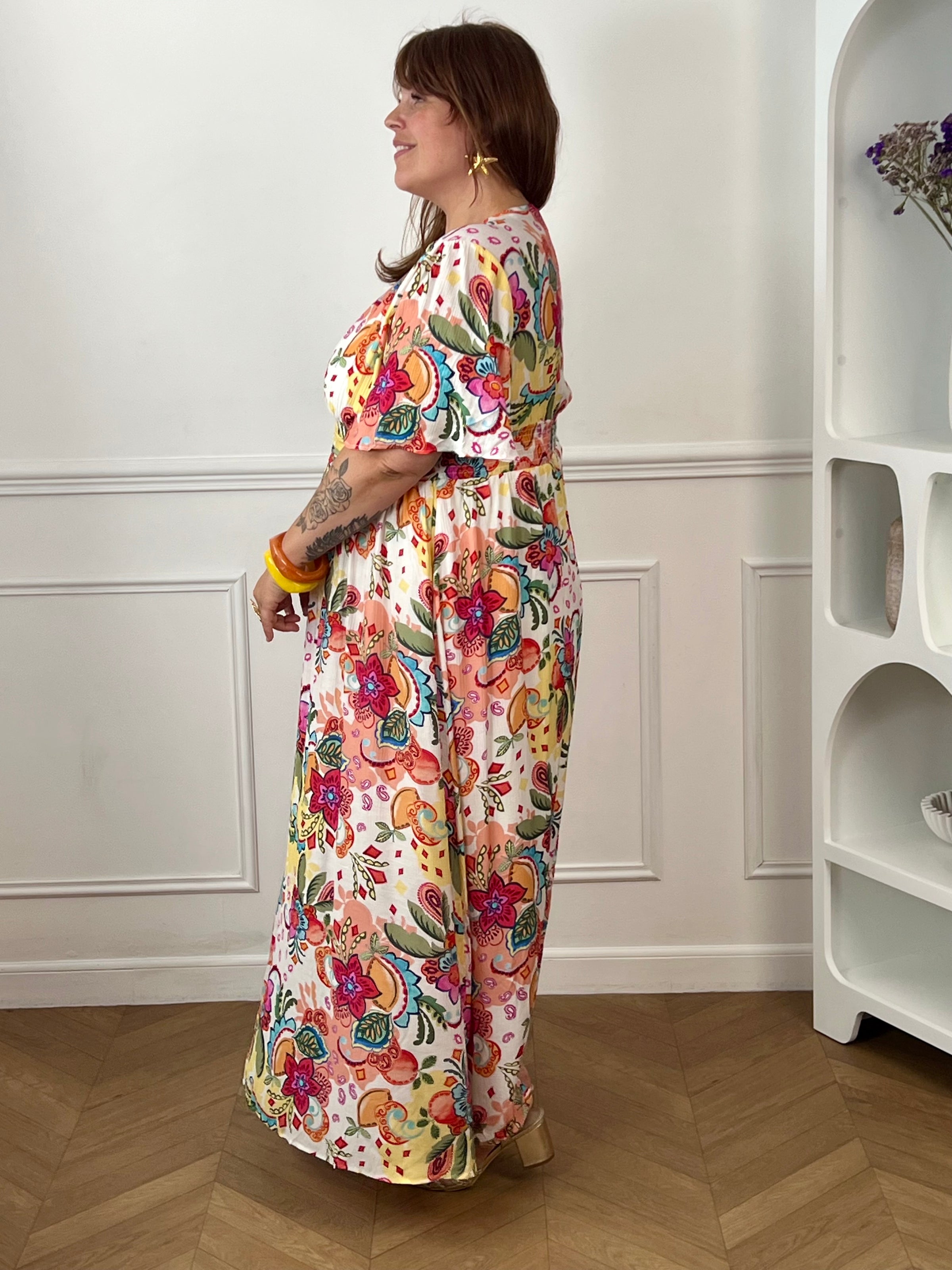 Succombez au charme de cette robe longue à motifs grande taille femme, idéale pour la saison. Son col V, ses manches courtes et sa taille élastiquée au dos offrent une coupe fluide et confortable. Doublée pour plus d'aisance, elle séduit par son imprimé multicolore aux tons écru, rose, bleu, jaune, orange, vert et rouge.
