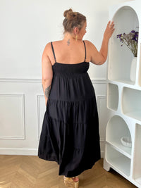 Apportez une touche d'élégance à votre garde-robe avec cette robe longue à bretelles femme. Son col V met délicatement la silhouette en valeur, tandis que les bretelles réglables et l'élastique au dos assurent un ajustement confortable et personnalisé. La broche dorée amovible en forme de soleil apporte une finition raffinée et originale, idéale pour sublimer cette robe noire. Une pièce chic et intemporelle, parfaite pour vos journées d'été comme pour vos occasions spéciales.