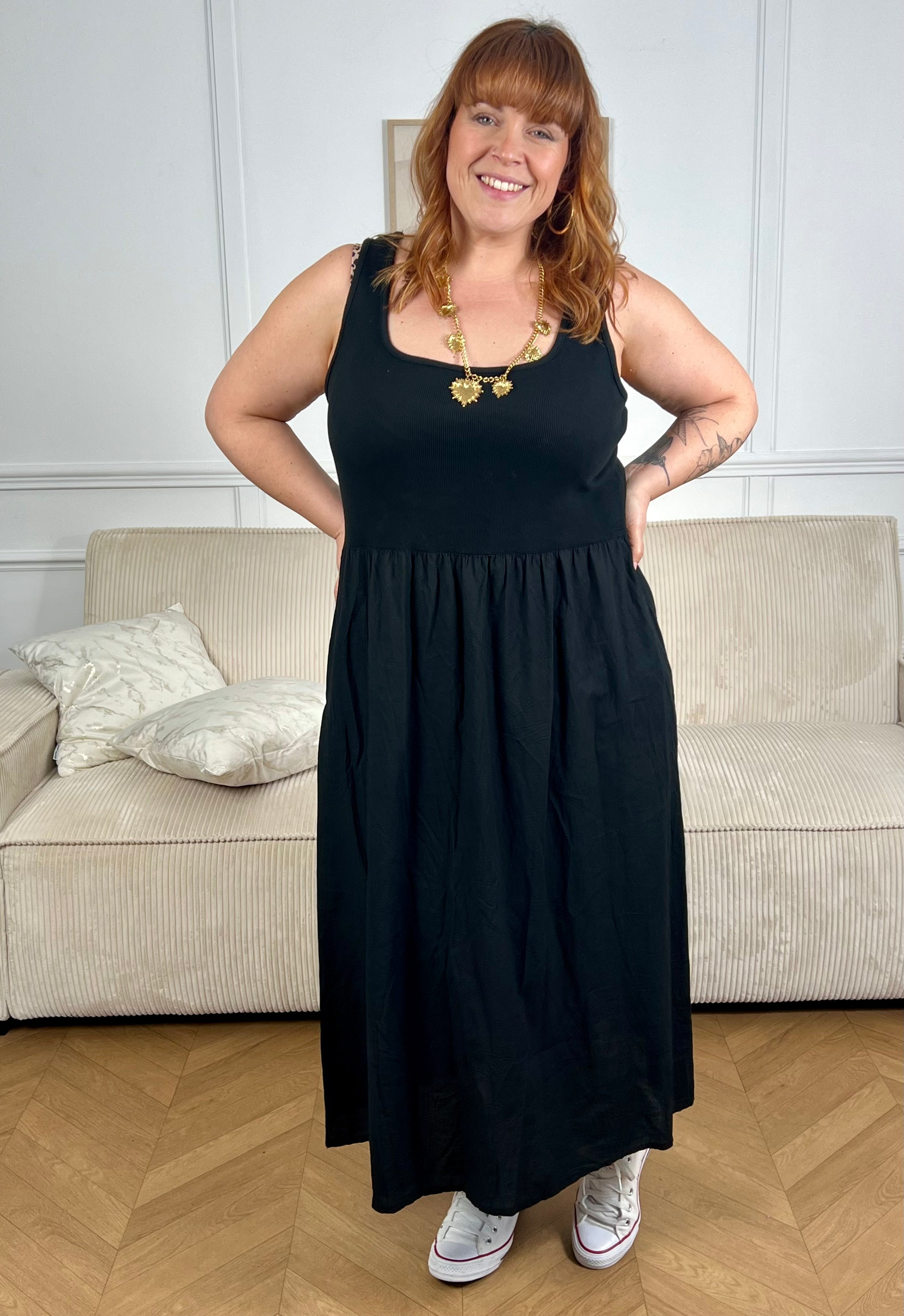 Succombez à cette robe en coton grande taille, alliant confort et style. Conçue en deux matières, elle se compose d’un haut type débardeur et d’un bas façon jupe longue pour une silhouette fluide et féminine. Dotée de deux poches latérales pratiques, cette robe noire grande taille est idéale pour un look casual et élégant au quotidien.