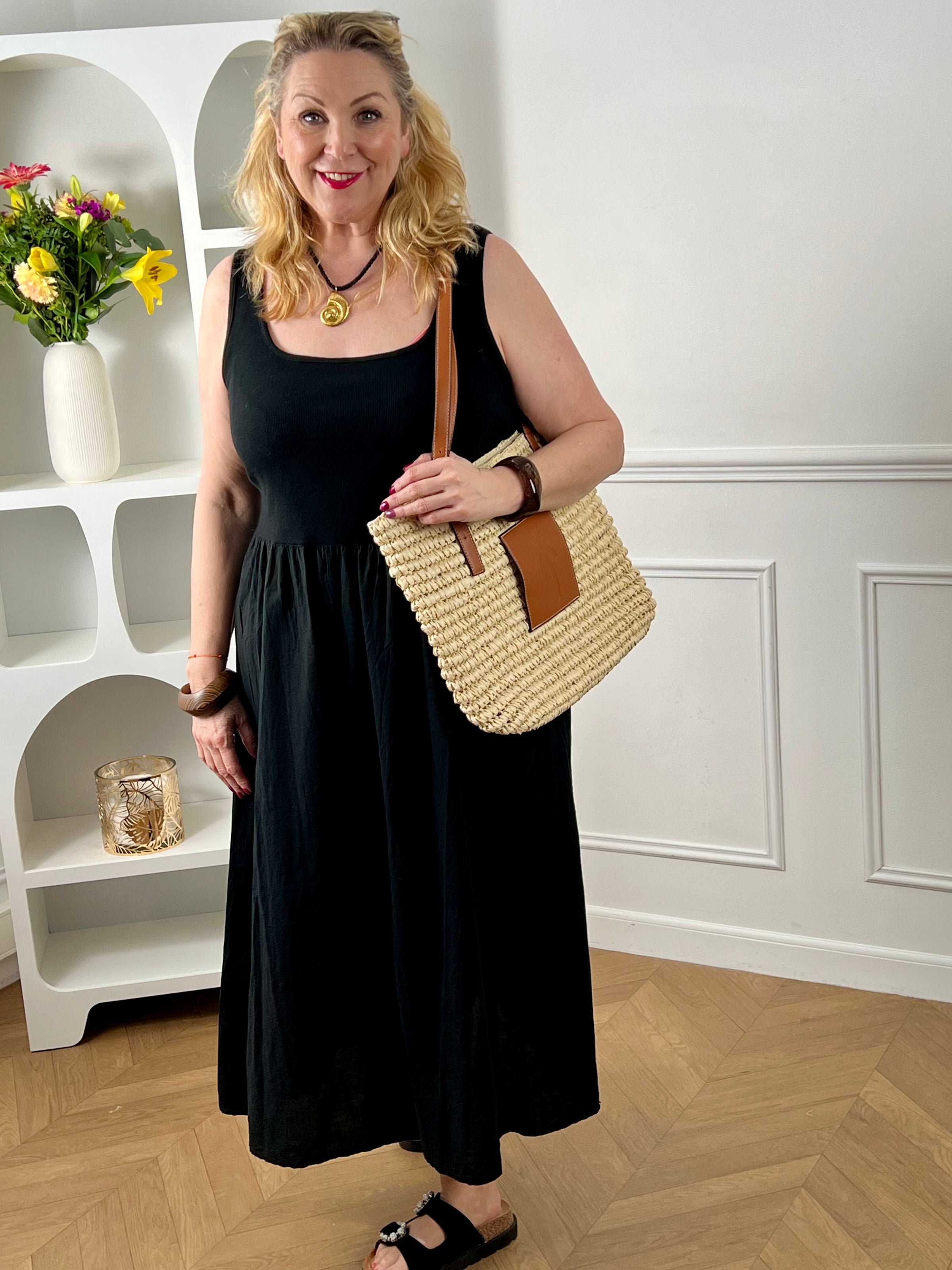 Succombez à cette robe en coton grande taille, alliant confort et style. Conçue en deux matières, elle se compose d’un haut type débardeur et d’un bas façon jupe longue pour une silhouette fluide et féminine. Dotée de deux poches latérales pratiques, cette robe noire grande taille est idéale pour un look casual et élégant au quotidien.