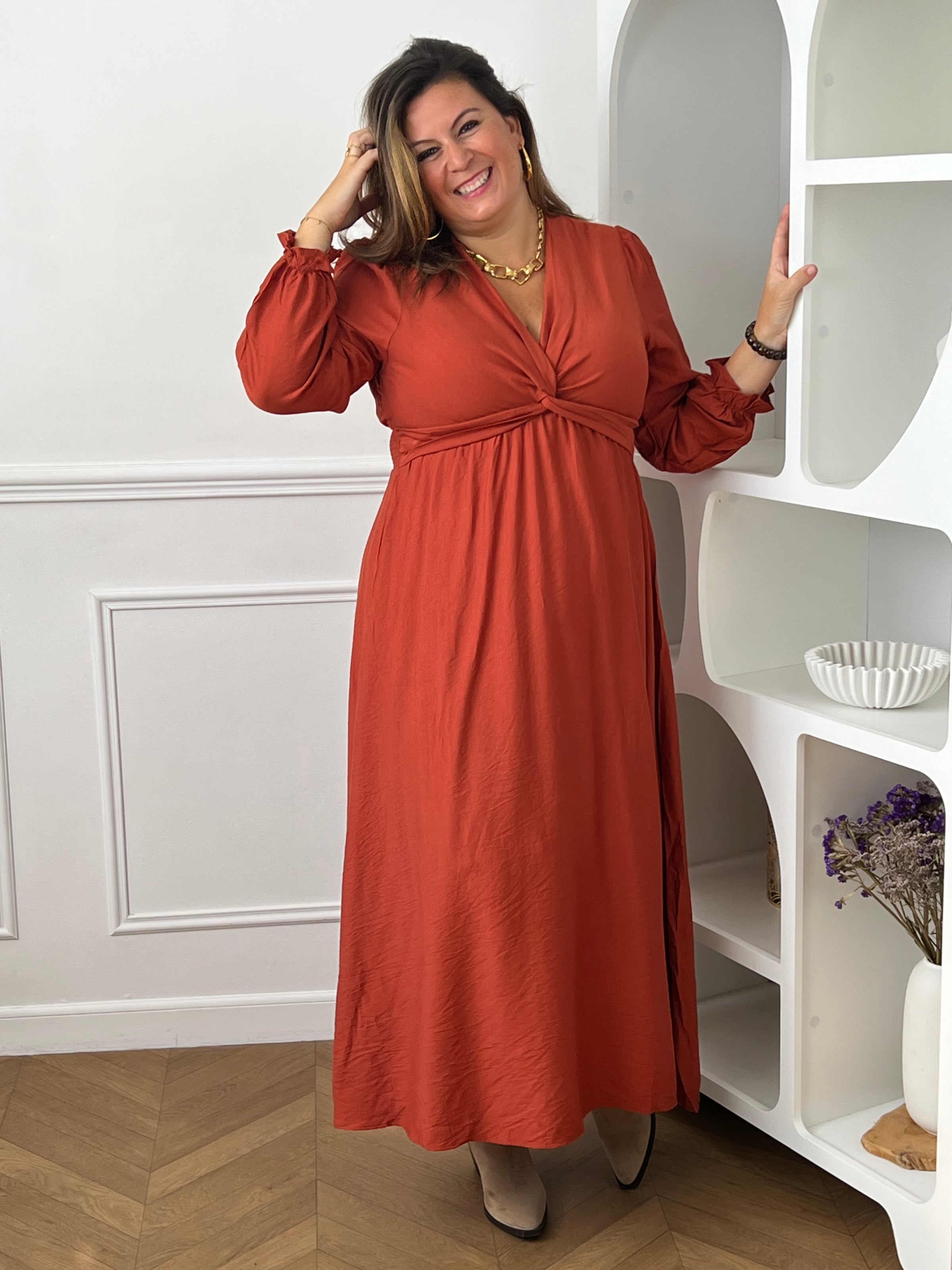 Robe terracotta grande taille à la coupe féminine et élégante.