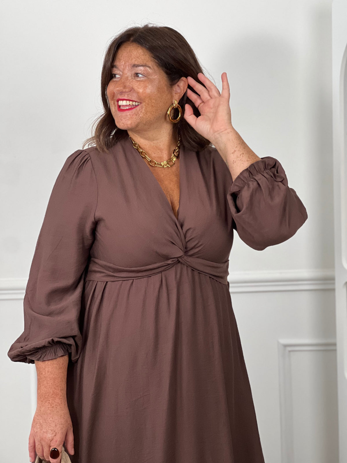 Détail col V croisé et taille empire robe marron chocolat grande taille – manches bouffantes curve – bijoux dorés – LoïciaDétail col V croisé et taille empire robe marron chocolat grande taille – manches bouffantes curve – bijoux dorés – Loïcia
