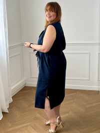 Adoptez cette robe en coton grande taille, à la fois confortable et structurée. Dotée d’un col chemise et de manches courtes avec revers, elle se ferme par des boutons. Sa ceinture amovible avec passants permet de marquer la taille. En noir, c’est une pièce intemporelle facile à porter au quotidien.