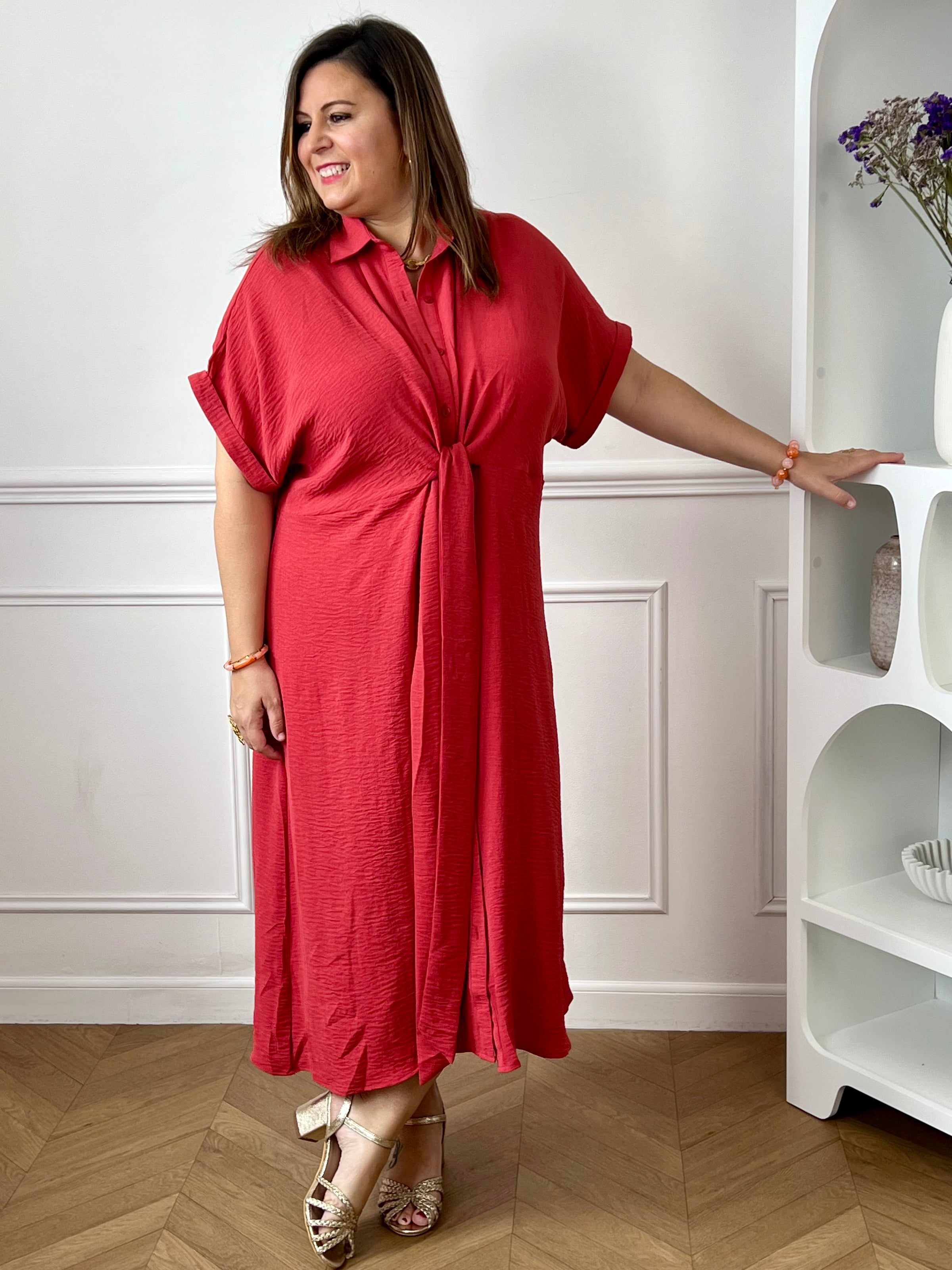 Adoptez un style naturel et élégant avec cette robe midi grande taille en coton. Sa longueur mi-longue, située entre le genou et le mollet, offre une silhouette féminine et confortable au quotidien. Dotée d’un col chemise, de manches courtes à revers et de boutons sur toute la longueur, elle allie praticité et raffinement. Les liens à nouer permettent de souligner délicatement la taille, tandis que sa couleur terracotta chaleureuse apporte une touche tendance et intemporelle à votre garde-robe.