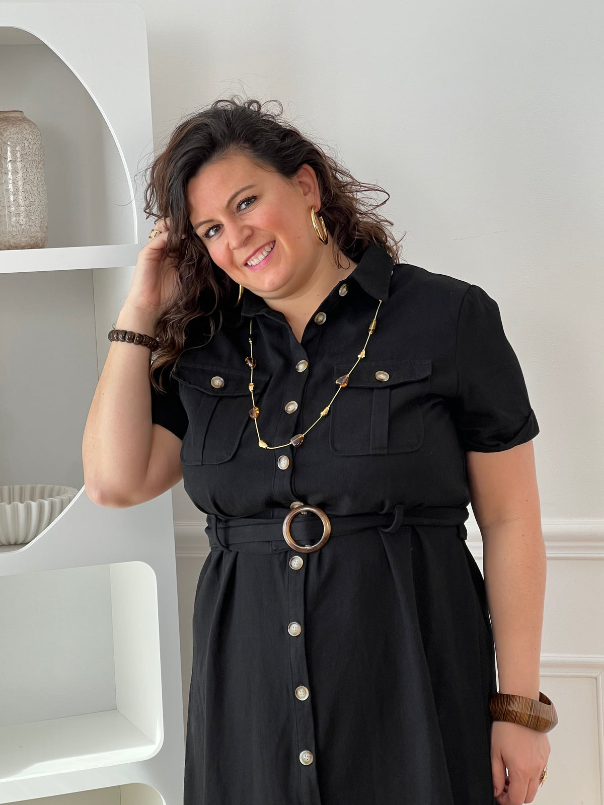 Adoptez cette robe en coton grande taille, à la fois confortable et structurée. Dotée d’un col chemise et de manches courtes avec revers, elle se ferme par des boutons. Sa ceinture amovible avec passants permet de marquer la taille. En noir, c’est une pièce intemporelle facile à porter au quotidien.