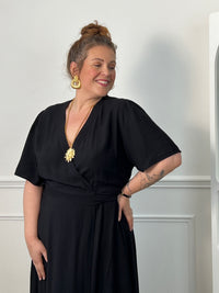 Sublimez votre silhouette avec cette robe longue grande taille au style élégant et féminin. Son col cache-cœur met délicatement le décolleté en valeur, tandis que l’élastique à la taille et aux poignets assure un confort optimal et un ajustement parfait. Le lien à nouer à la taille crée un joli effet portefeuille qui souligne la silhouette avec raffinement. Avec ses manches courtes et sa couleur noire intemporelle, cette robe est idéale pour toutes les occasions, du quotidien aux événements plus habillés.