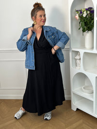 Sublimez votre silhouette avec cette robe longue grande taille au style élégant et féminin. Son col cache-cœur met délicatement le décolleté en valeur, tandis que l’élastique à la taille et aux poignets assure un confort optimal et un ajustement parfait. Le lien à nouer à la taille crée un joli effet portefeuille qui souligne la silhouette avec raffinement. Avec ses manches courtes et sa couleur noire intemporelle, cette robe est idéale pour toutes les occasions, du quotidien aux événements plus habillés.
