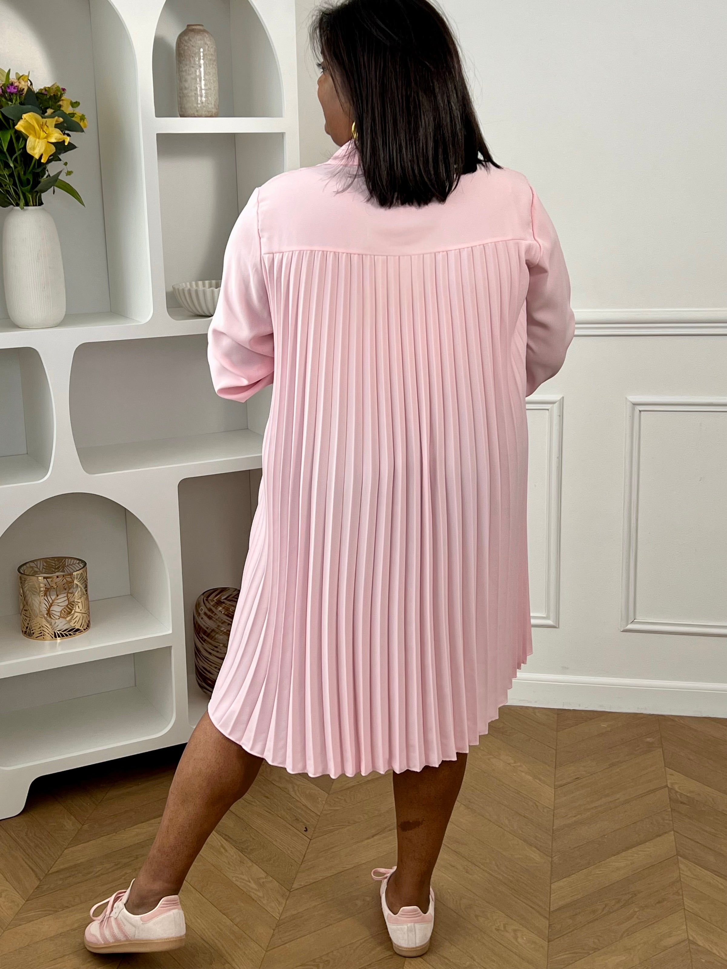 La texture plissée ajoute une touche de mouvement et de style, tandis que la couleur rose apporte une note classique. Cette pièce est idéale pour des occasions décontractées ou plus habillées, permettant aux femmes de grande taille de rayonner avec confiance dans une robe chic et flatteuse.