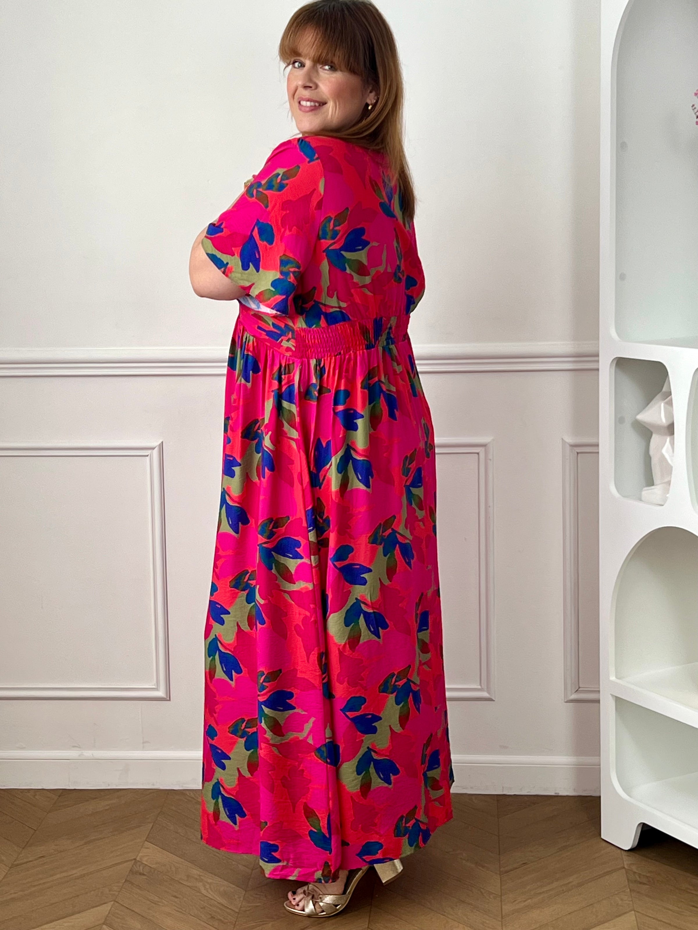 Cette robe longue fuchsia aux motifs corail bleu et vert allie confort et élégance grâce à sa coupe fluide qui sublime la silhouette. Son col en V et ses manches courtes apportent une touche de fraîcheur et de féminité.