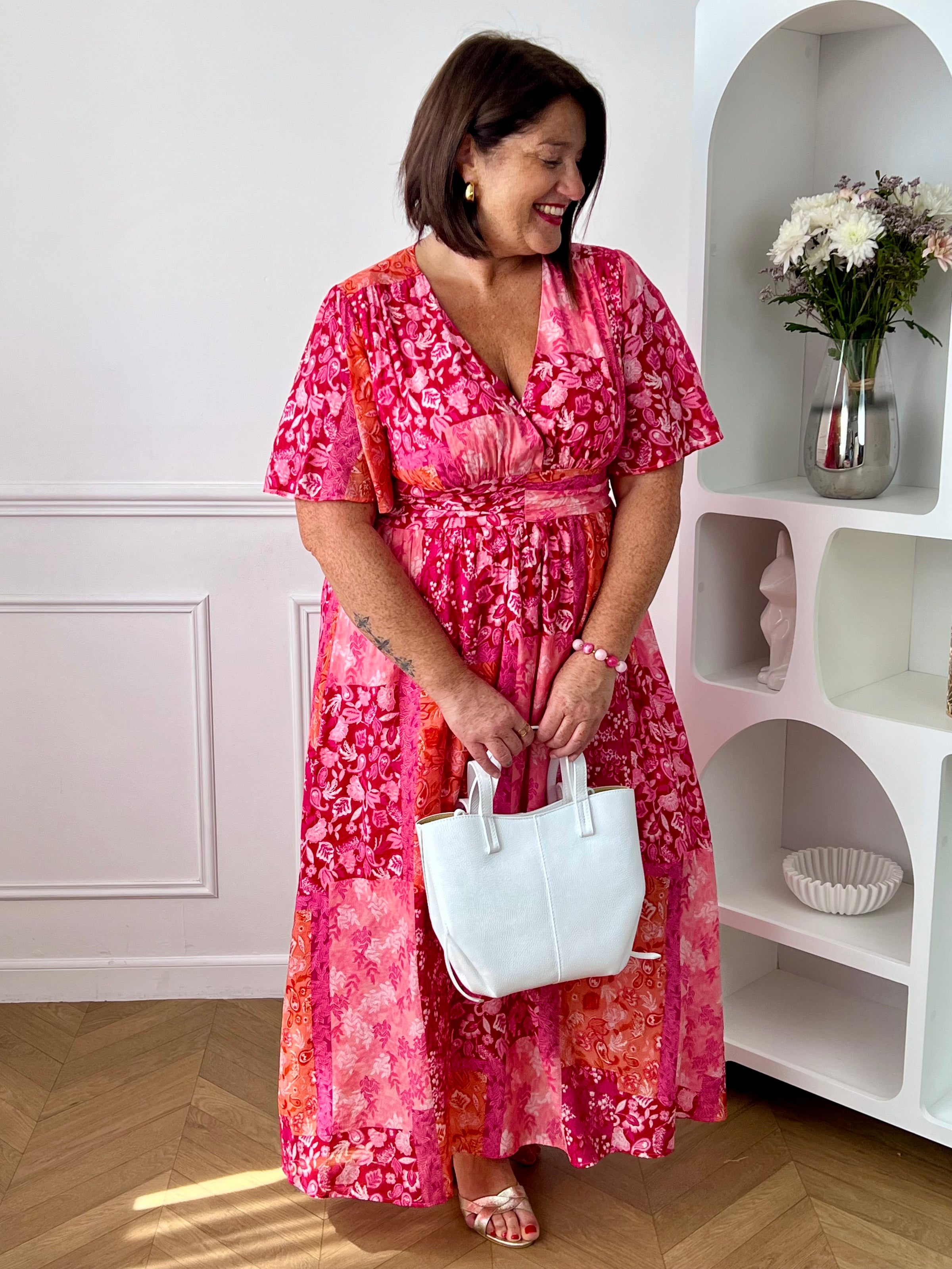 Ajoutez une touche de couleur à votre dressing avec cette robe longue à motifs grande taille femme. Son col V et ses manches courtes lui confèrent une allure élégante et féminine, tandis que sa taille élastiquée au dos assure un confort optimal et une silhouette harmonieuse. Ses motifs dans des nuances de fuchsia et de rose clair apportent une note lumineuse et tendance, parfaite pour la belle saison.