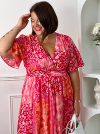 Ajoutez une touche de couleur à votre dressing avec cette robe longue à motifs grande taille femme. Son col V et ses manches courtes lui confèrent une allure élégante et féminine, tandis que sa taille élastiquée au dos assure un confort optimal et une silhouette harmonieuse. Ses motifs dans des nuances de fuchsia et de rose clair apportent une note lumineuse et tendance, parfaite pour la belle saison.