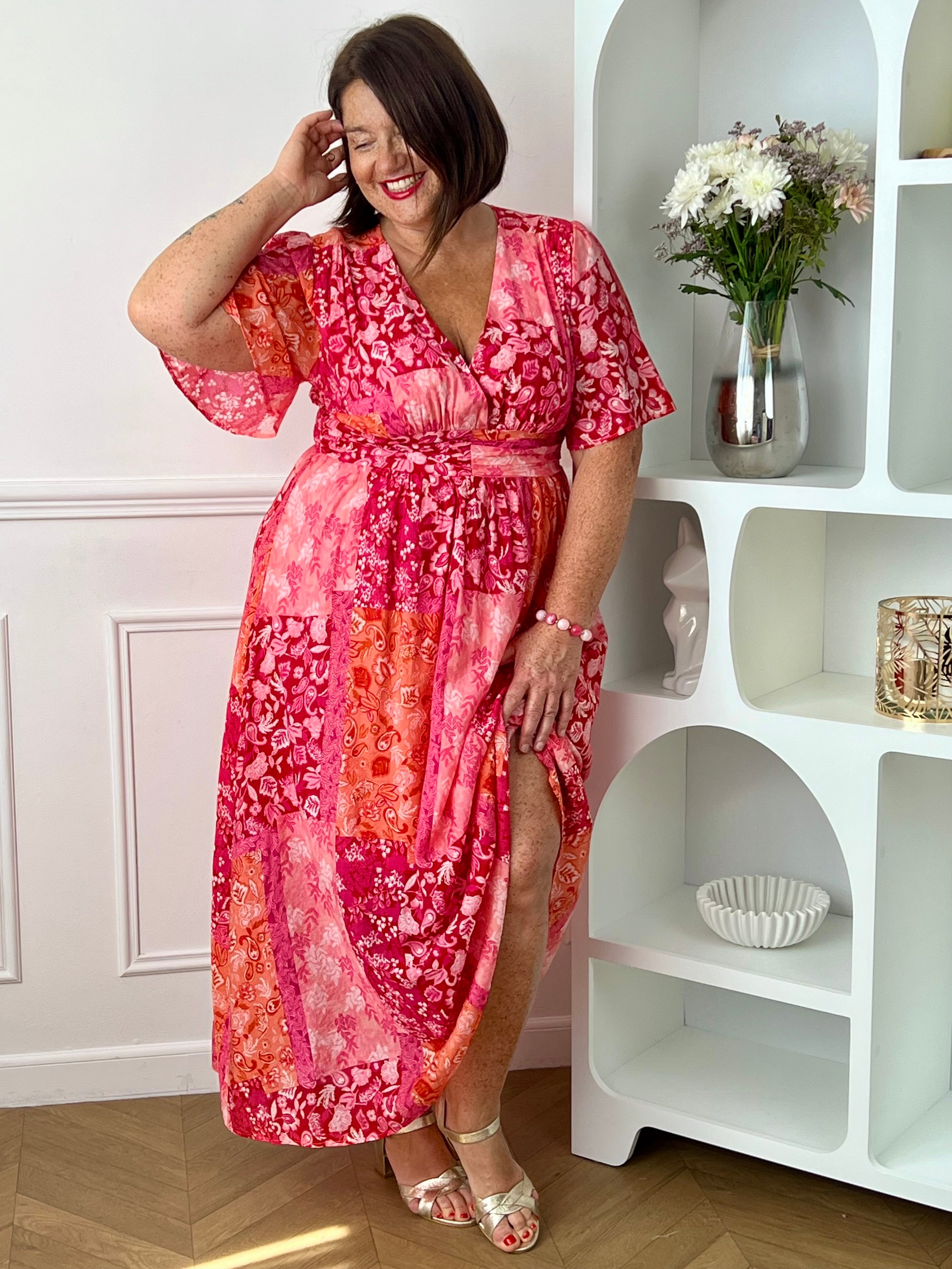 Ajoutez une touche de couleur à votre dressing avec cette robe longue à motifs grande taille femme. Son col V et ses manches courtes lui confèrent une allure élégante et féminine, tandis que sa taille élastiquée au dos assure un confort optimal et une silhouette harmonieuse. Ses motifs dans des nuances de fuchsia et de rose clair apportent une note lumineuse et tendance, parfaite pour la belle saison.