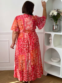 Ajoutez une touche de couleur à votre dressing avec cette robe longue à motifs grande taille femme. Son col V et ses manches courtes lui confèrent une allure élégante et féminine, tandis que sa taille élastiquée au dos assure un confort optimal et une silhouette harmonieuse. Ses motifs dans des nuances de fuchsia et de rose clair apportent une note lumineuse et tendance, parfaite pour la belle saison.