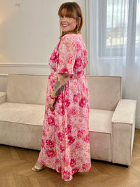 Cette robe rose clair, sublimée par des motifs rose foncé et beige, allie douceur et élégance. Ses détails argentés brillants apportent une touche lumineuse et raffinée, idéale pour une silhouette féminine et sophistiquée.
