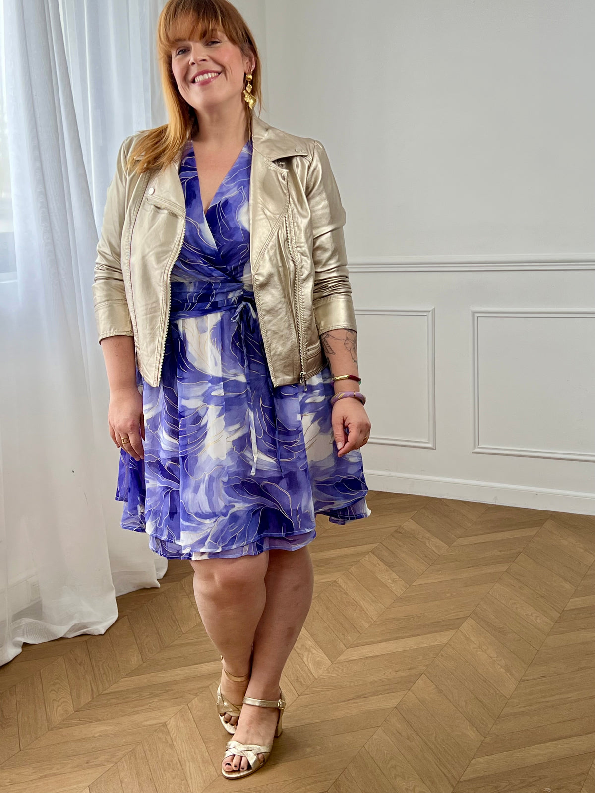 Cette robe violette et écru grande taille femme, élégante et lumineuse. Dotée de manches courtes et d’un col cache-cœur, elle sublime la silhouette avec féminité. Son élastique au dos et aux poignets assure confort et maintien. Doublée (sauf aux manches) et agrémentée de détails dorés, elle est complétée par un lien factice à nouer à l’avant pour une touche raffinée.