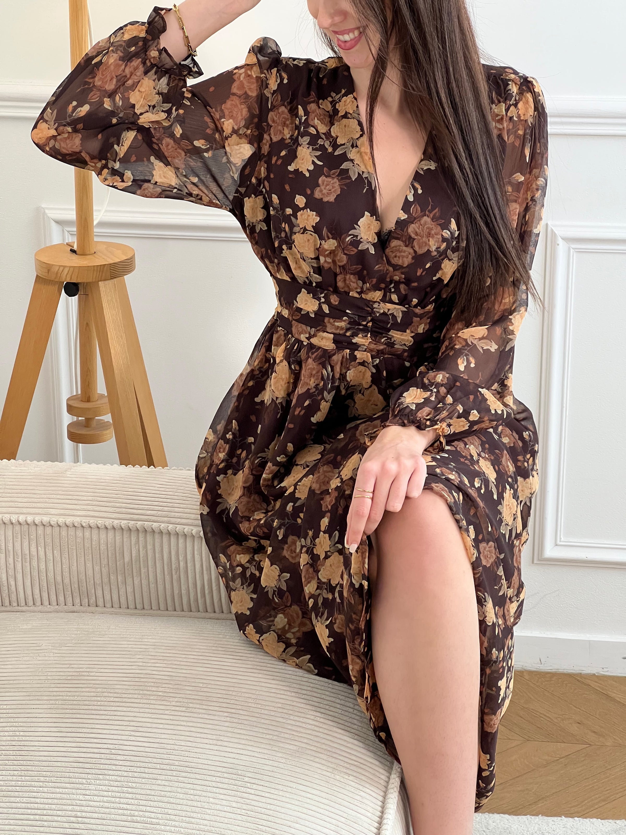 Découvrez la robe longue Eïra, une pièce élégante qui allie style et confort. Confectionnée en marron et noir avec un délicat motif floral, elle séduira les femmes en quête de sophistication. Ses manches longues ornées de volants ajoutent une touche romantique, tandis que le col V affine la silhouette.&nbsp;