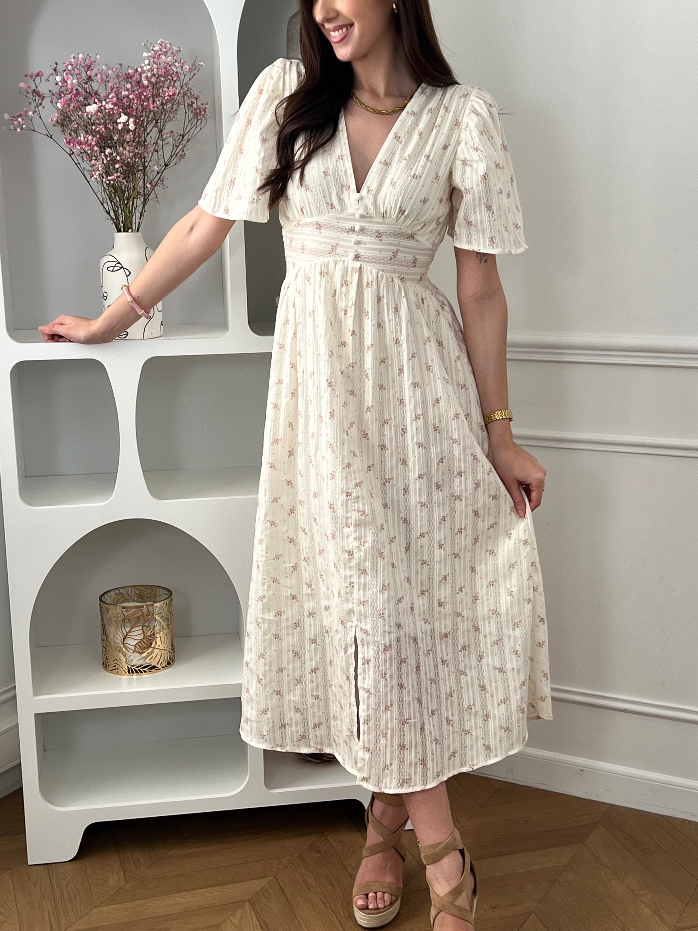 Craquez pour cette robe longue femme, élégante et féminine. Dotée d’un col V et de manches courtes, elle se distingue par ses motifs fleurs et ses détails en dentelle. Doublée sur le devant du haut et la jupe jusqu’à mi-longueur, elle assure confort et opacité. Ses couleurs beige, rose et marron apportent une touche douce et raffinée.