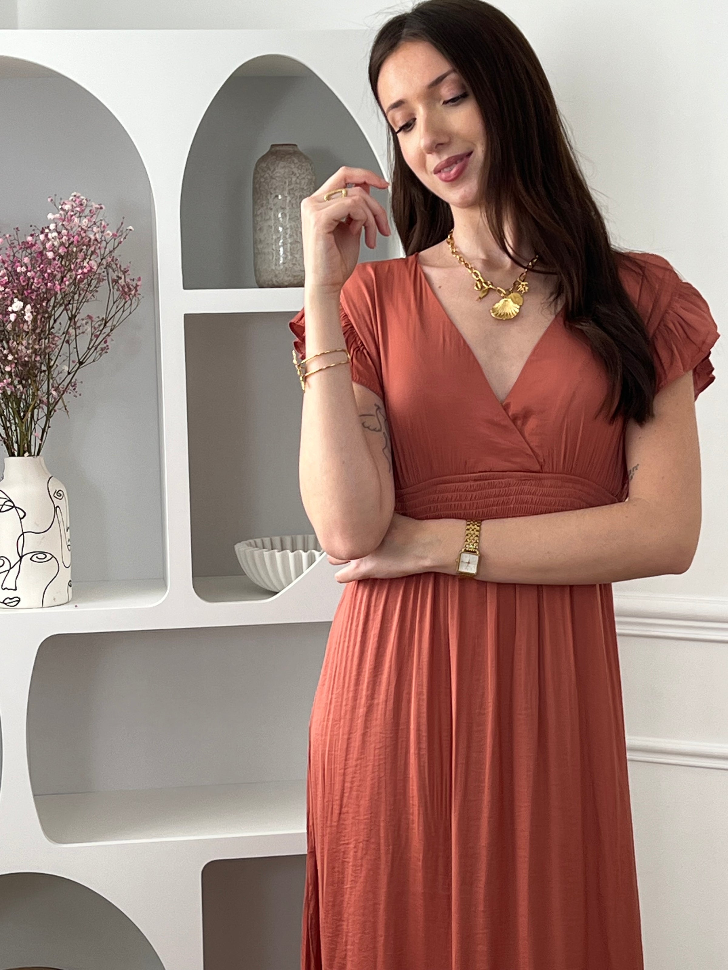 Craquez pour cette robe longue femme terracotta, élégante et féminine. Sans manches, elle se distingue par ses volants aux épaules et son col V plongeant qui sublime le décolleté. Son dos nu avec lien à nouer apporte une touche raffinée, tandis que sa taille élastique assure confort et maintien. Une pièce idéale pour un look chic et estival.